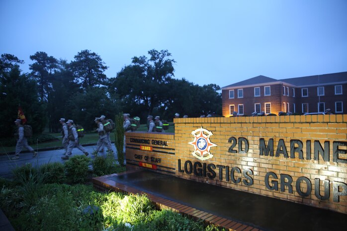 Service members with Combat Logistics Battalion 2, Combat Logistics Regiment 2, 2nd Marine Logistics Group walk around the 2nd MLG headquarters sign during a battalion conditioning hike aboard Camp Lejeune, N.C., Oct. 10, 2013. The 2nd MLG headquarters building served at the halfway mark for the battalion’s approximately 3.8-mile hike in the rain. 