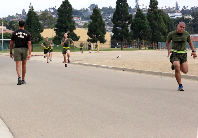 Students of DI School, class 1-14, push on to the finish line during their initial Physical Fitness Test aboard the depot, Oct. 1. Marines were motivated by Maj. Adrian B. Haskamp, director of Drill Instructor School, who had already finished the 3-mile run portion of the PFT.