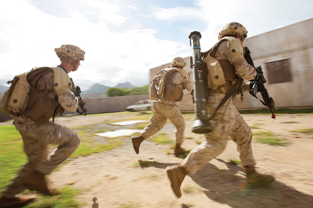 Marines with first platoon, Charlie Company, 1st Battalion, 3rd Marine Regiment, dart across a danger area to clear remaining compounds in their area of operation at Marine Corps Training Area Bellows, Hawaii, Sept. 30, 2013. The Marines conducted Military Operations in Urban Terrain training to enhance skills in urban war fighting. (U.S. Marine Corps photo by Cpl. Matthew Callahan)