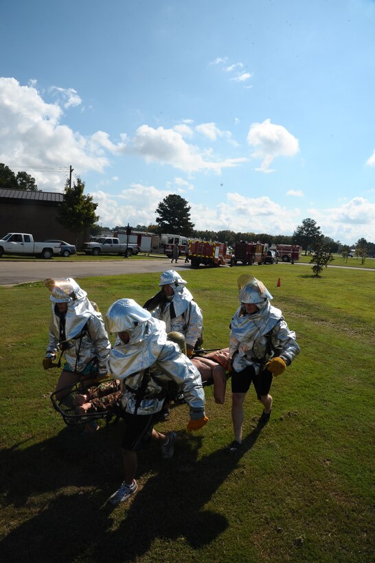 A team of Airmen lift a 210 pound dummy in a competition at the Base Fire Muster Oct. 10 at the Old Fuels Yard on Simler Blvd. (U.S. Air Force Photo/Airman Daniel Lile)