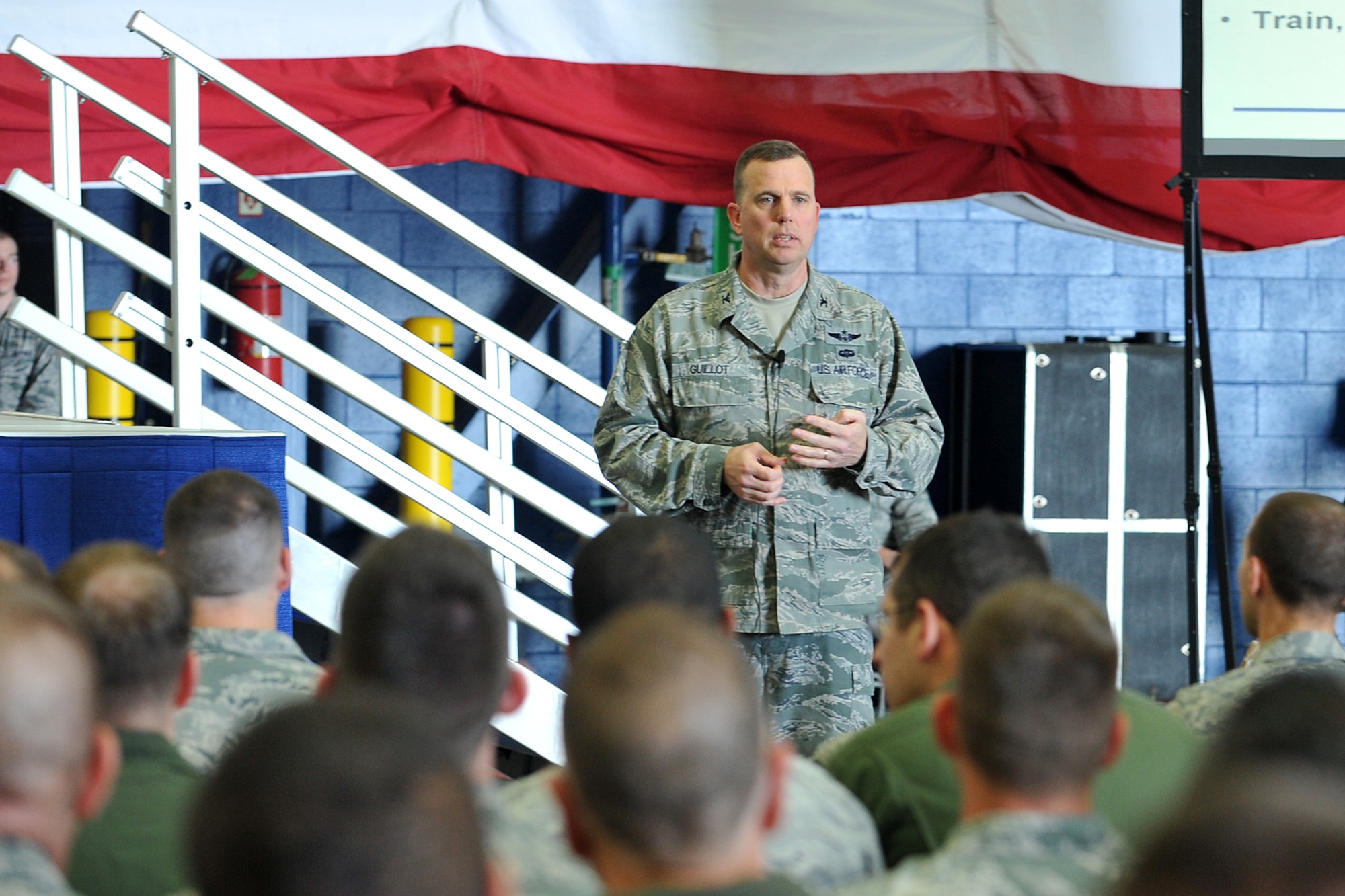 Col. Gregory Guillot, 55th Wing commander, addresses members of the wing during one of his commanders calls at the Bennie Davis Maintenance Facility on Oct. 11, at Offutt Air Force Base, Neb. Guillot highlighted some of the Fightin' Fifty Fifth's accolades earned over the past 12 months as well as provided as much information as he had about the ongoing government shutdown. (U.S. Air Force photo by Charles Haymond/Released)