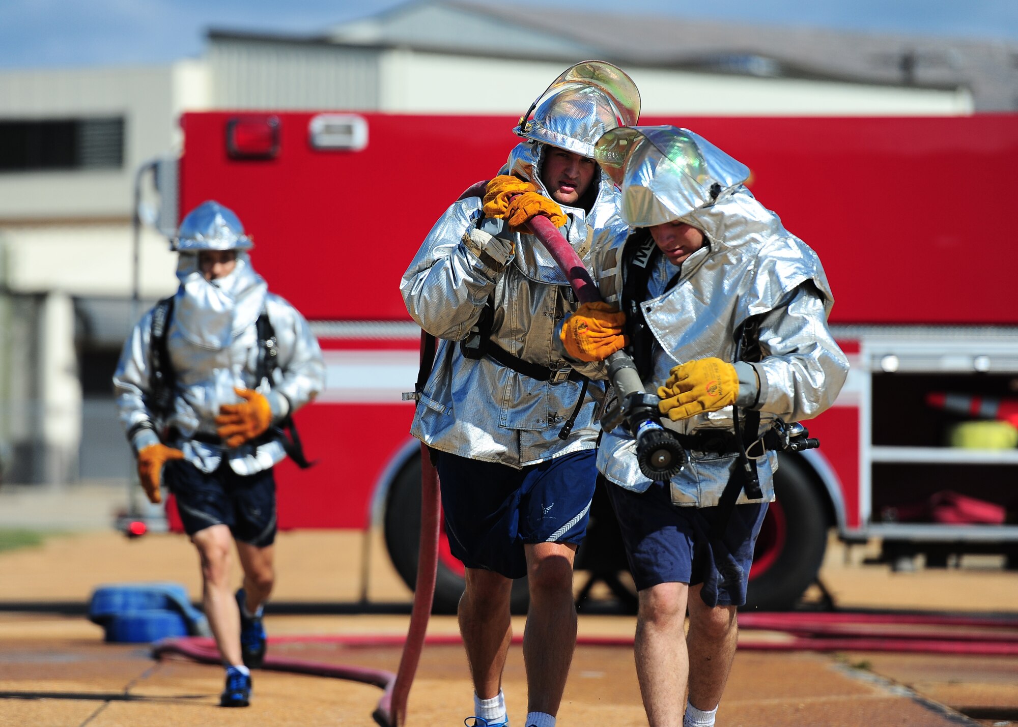 A team of Airman finish the competition by running with the fire hose and opening the valve at the Base Fire Muster Competition at the Old Fuels Yard on Simler Blvd. (U.S. Air Force Photo/ Airman 1st Class Stephanie Englar)