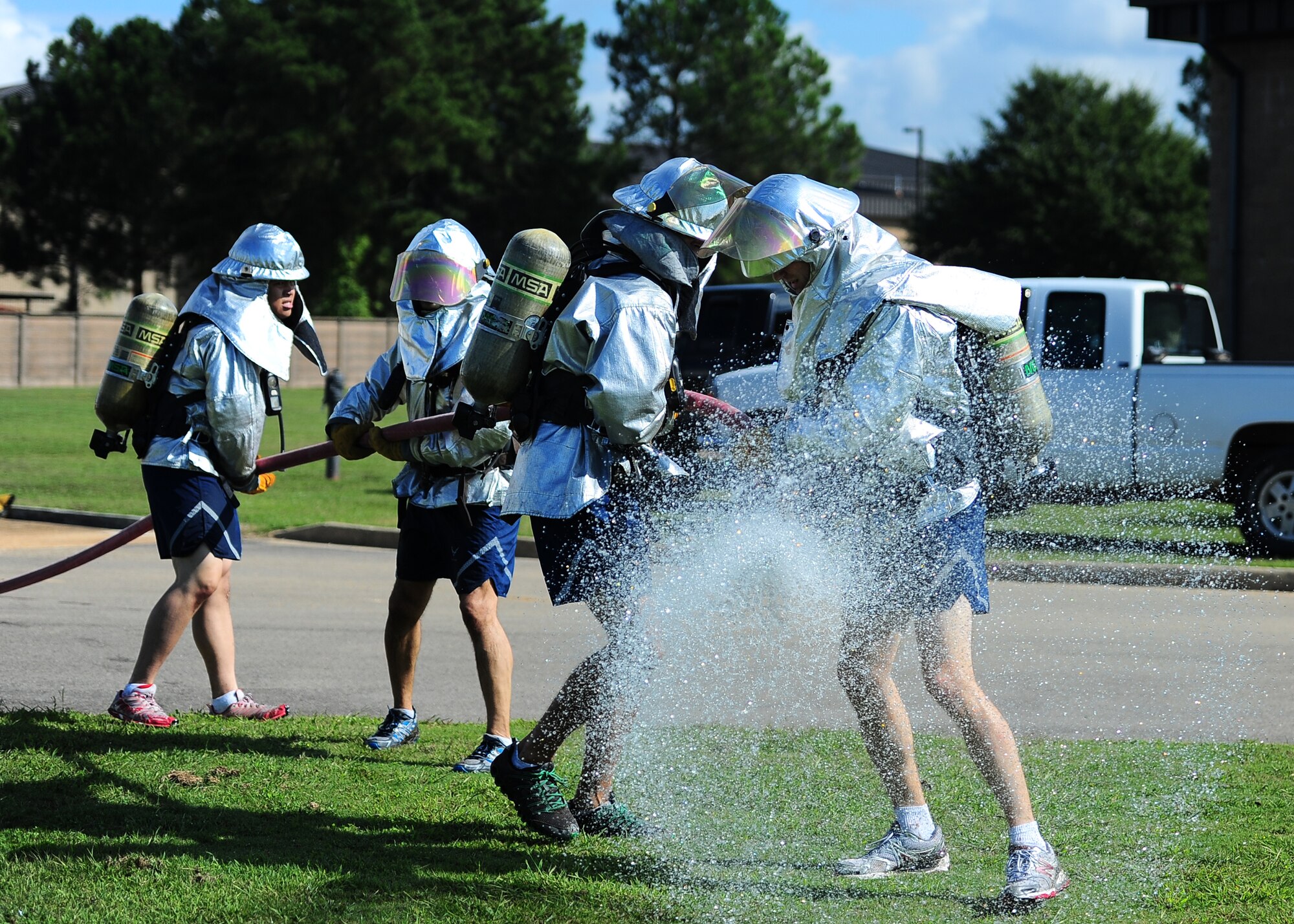 A team of Airman finish the competition by running with the fire hose and opening the valve at the Base Fire Muster Competition at the Old Fuels Yard on Simler Blvd. (U.S. Air Force Photo/ Airman 1st Class Stephanie Englar)