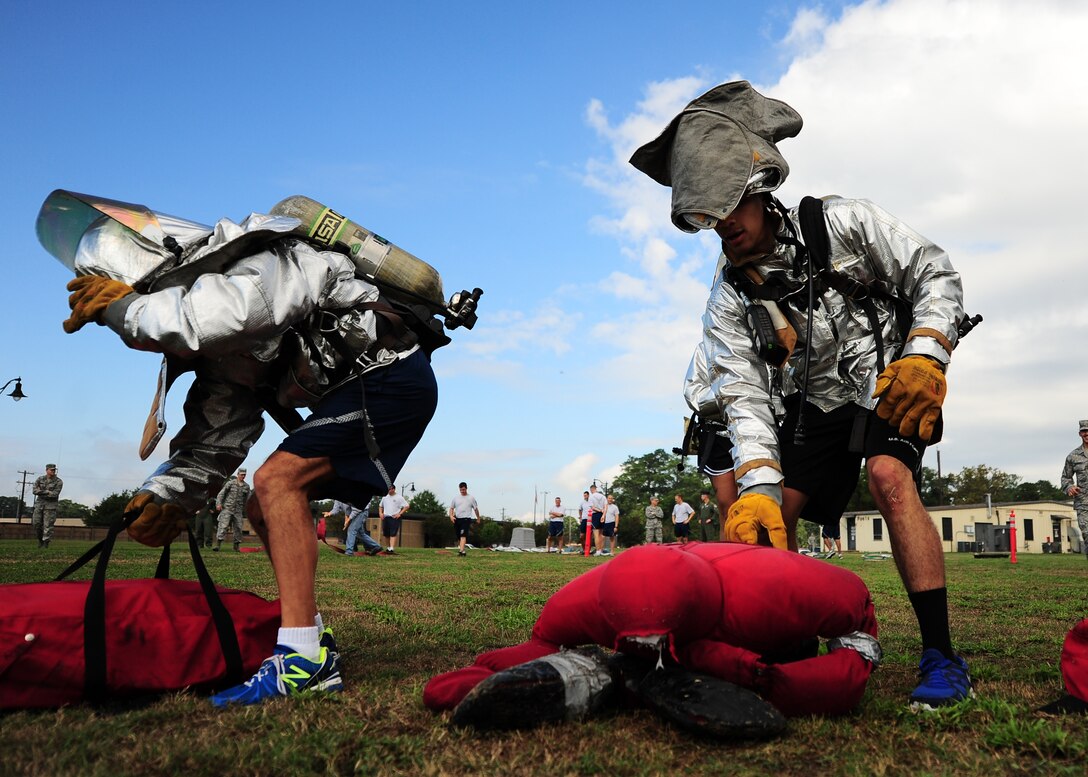 A team of Airmen lift 210 pound dummies in a competition at the Base Fire Muster Oct. 10 at the Old Fuels Yard on Simler Blvd. (U.S. Air Force Photo/Airman 1st Class Stephanie Englar)