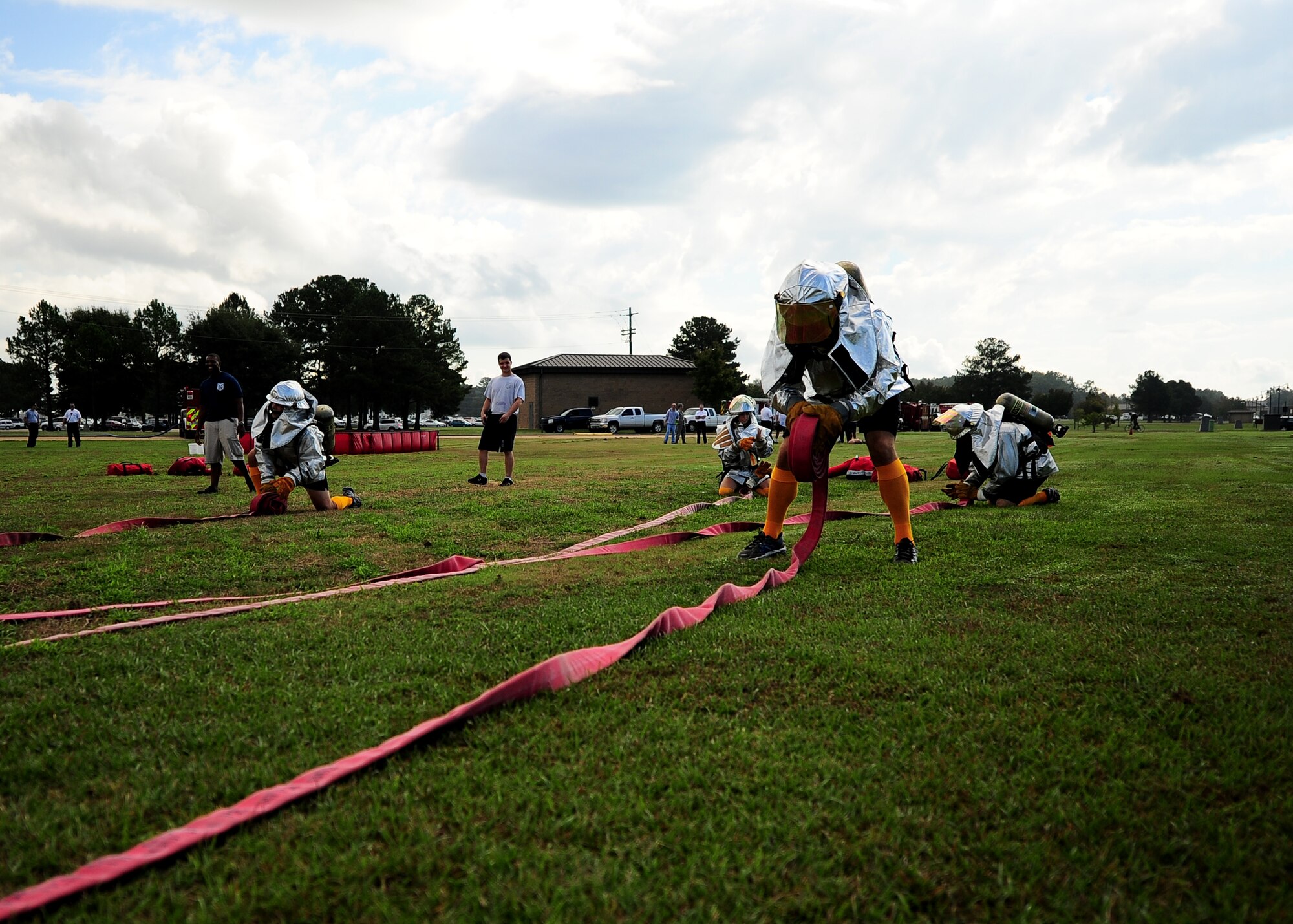 A team of Airmen roll 150 ft. 2.5-inch hoses in a competition at the Base Fire Muster Oct. 10 at the Old Fuels Yard on Simler Blvd. (U.S. Air Force Photo/Airman 1st Class Stephanie Englar)