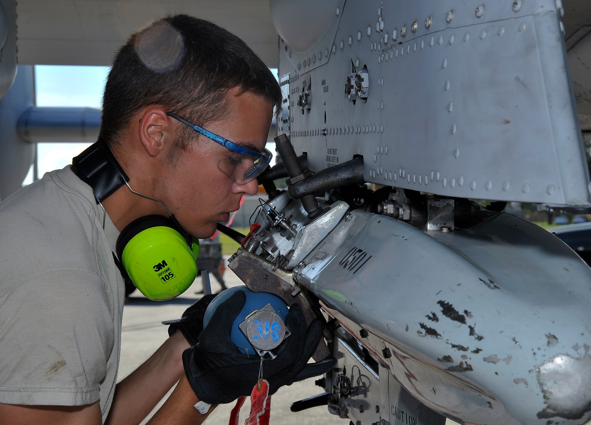 Senior Airman Anthony Page, 442nd Aircraft Maintenance Squadron A-10 armament specialist, concentrates on loading an inert explosive device onto an aircraft Oct. 8, 2013, at MacDill Air Force Base, Fla., Personnel from Whiteman Air Force Base, Mo., visited MacDill to practice for real world missions. (U.S. Air Force photo by Airman 1st Class Sarah Hall-Kirchner/Released)