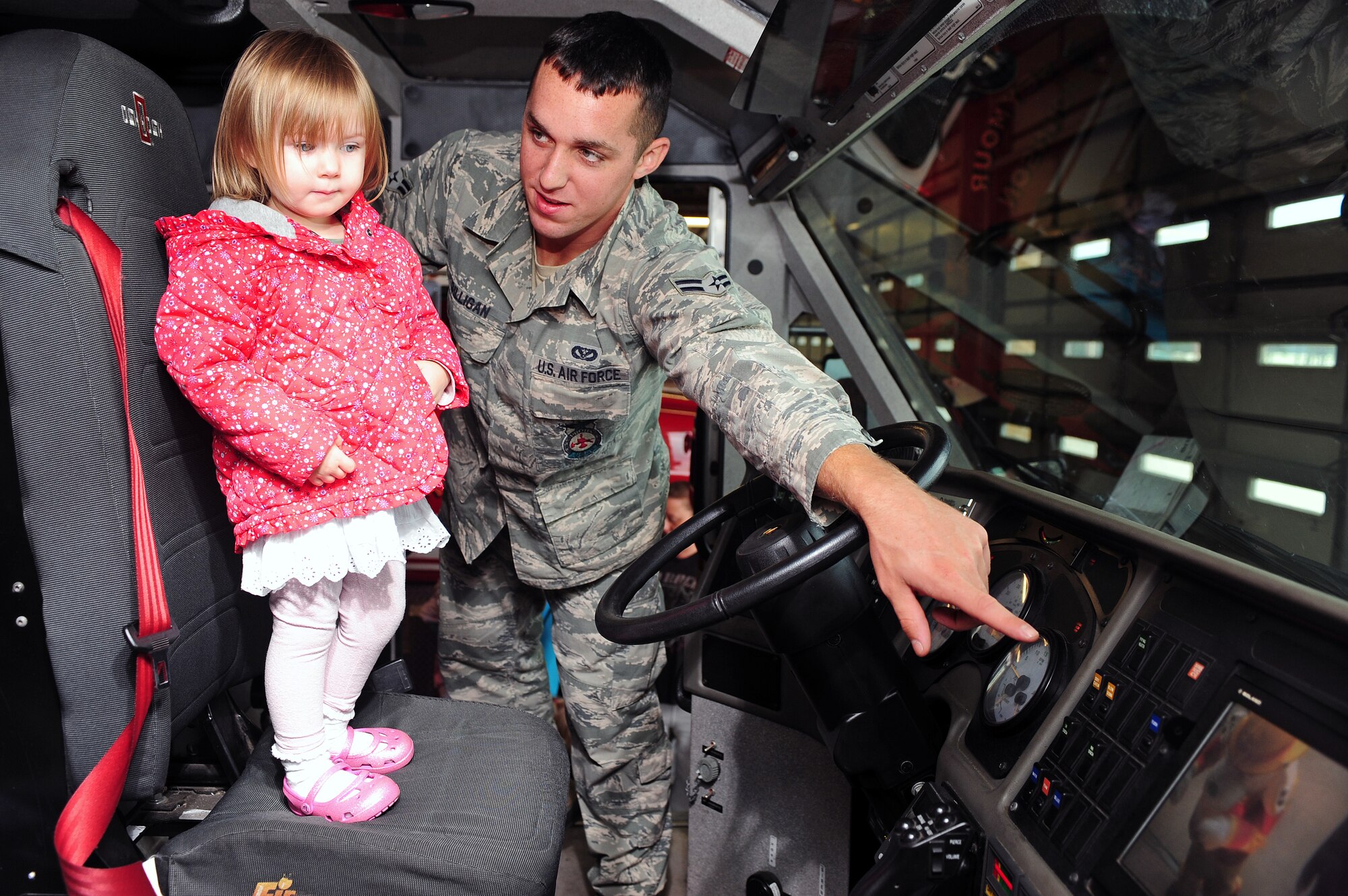 U.S. Air Force Airman 1st Class Michael Gilligan, 4th Civil Engineer Squadron firefighter, shows a child the different gauges on a fire truck at Seymour Johnson Air Force Base, N.C., Oct. 9, 2013. Gilligan led children from the child development center on a tour of the fire department where they learned about fire prevention and safety. (U.S. Air Force photo by Airman 1st Class John Nieves Camacho) 