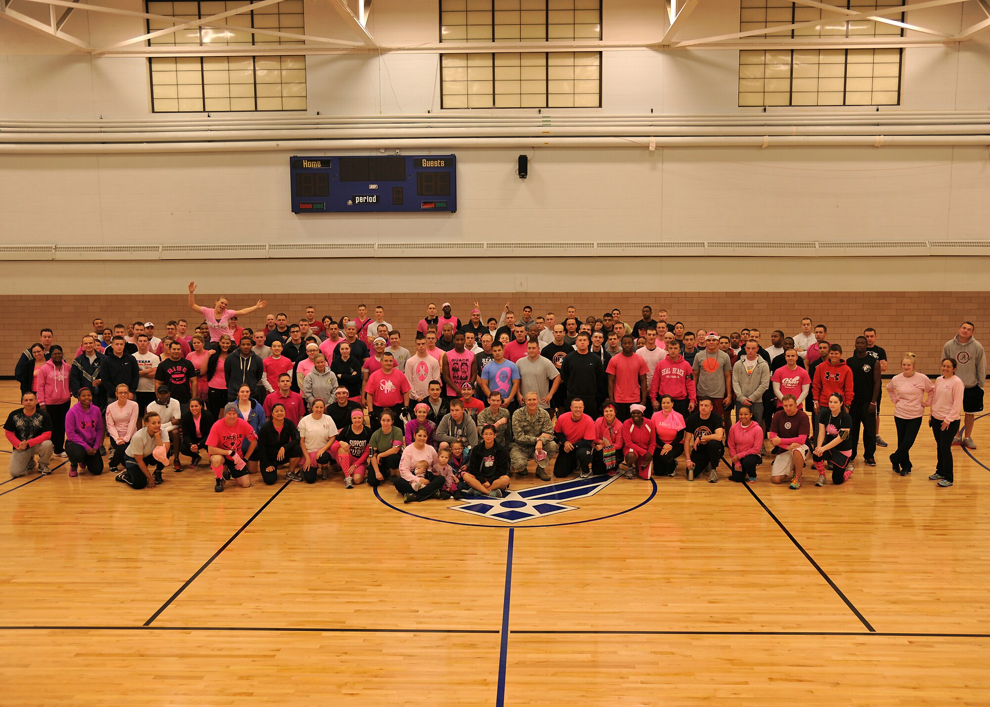 Airmen, civilians and family members from the 319th Air Base Wing pose for a group photo inside Gym 1 of the base fitness center before the start of the Breast Cancer Awareness 5K hosted by the 319th Medical Group  Oct. 10, 2013, at the 5-kilometer trail on Grand Forks Air Force Base, N.D . Approximately 100 people attended the event as walkers, joggers, runners or spectators who cheered on participants.  (U.S. Air Force photo/Senior Airman Xavier Navarro)