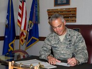 Col. Robert Vercher, 91st Missile Wing commander, signs his Combined Federal Campaign contribution sheet. The 2013 CFC is currently underway, and Key Workers are ready to accept contributions. The 5th Bomb Wing Commander, Col. Alex Mezynski, has also completed his contribution forms, and along with Vercher, they both encourage all to do so as well. CFC provides military members and Federal employees the opportunity to support the many organizations that strengthen the military community and assist national charities as well. (U.S. Air Force photo/Senior Airman Kristoffer Kaubisch)