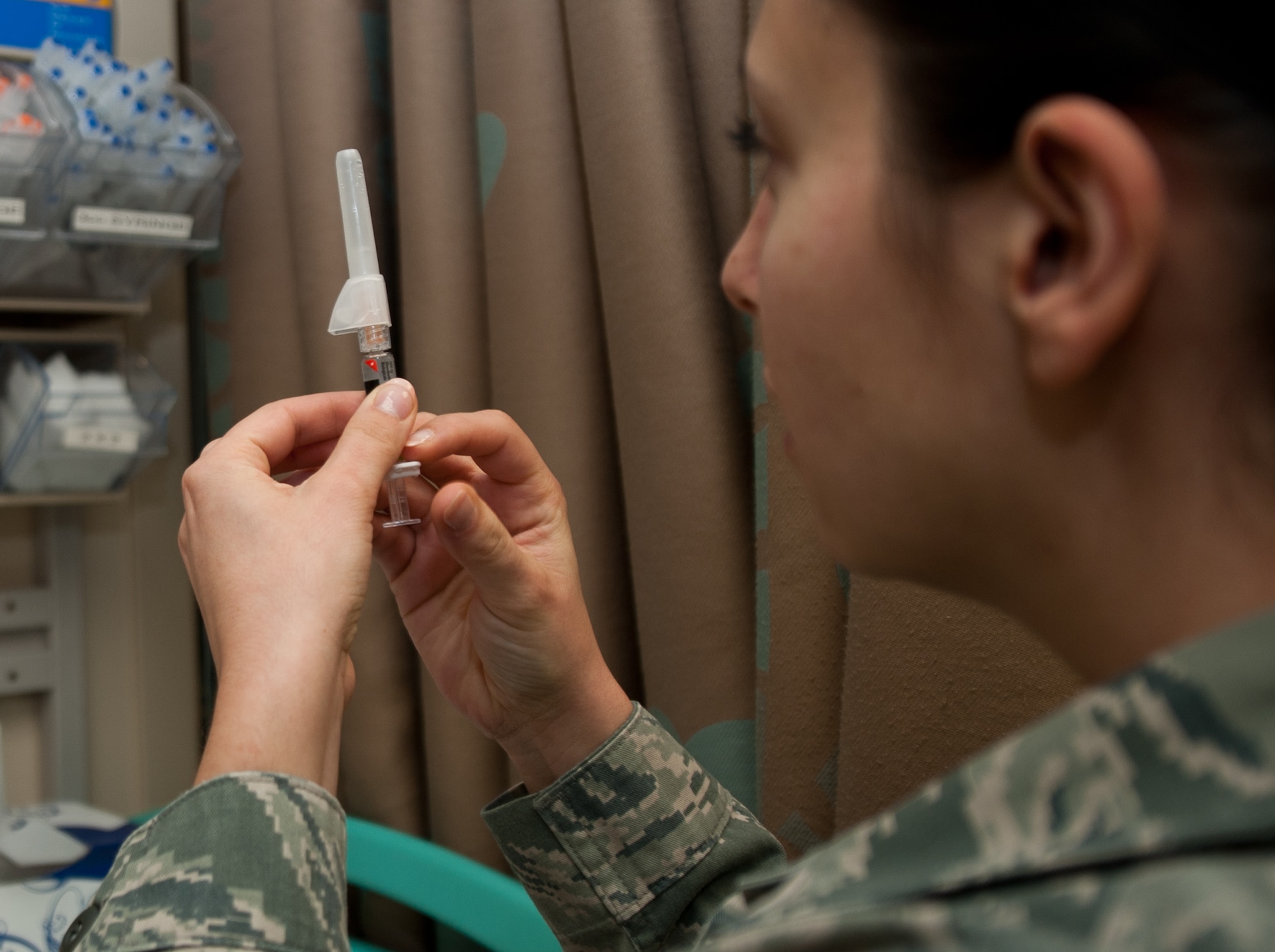 Senior Airman Nathalia Gillenwater, 28th Medical Operations Squadron allergy and immunizations technician, prepares to administer a vaccination at Ellsworth Air Force Base, S.D., Oct. 3, 2013. The immunizations clinic provides vaccinations to more than 1,500 beneficiaries in the Black Hills area. (U.S. Air Force photo by Airman 1st Class Alystria Maurer/Released)
