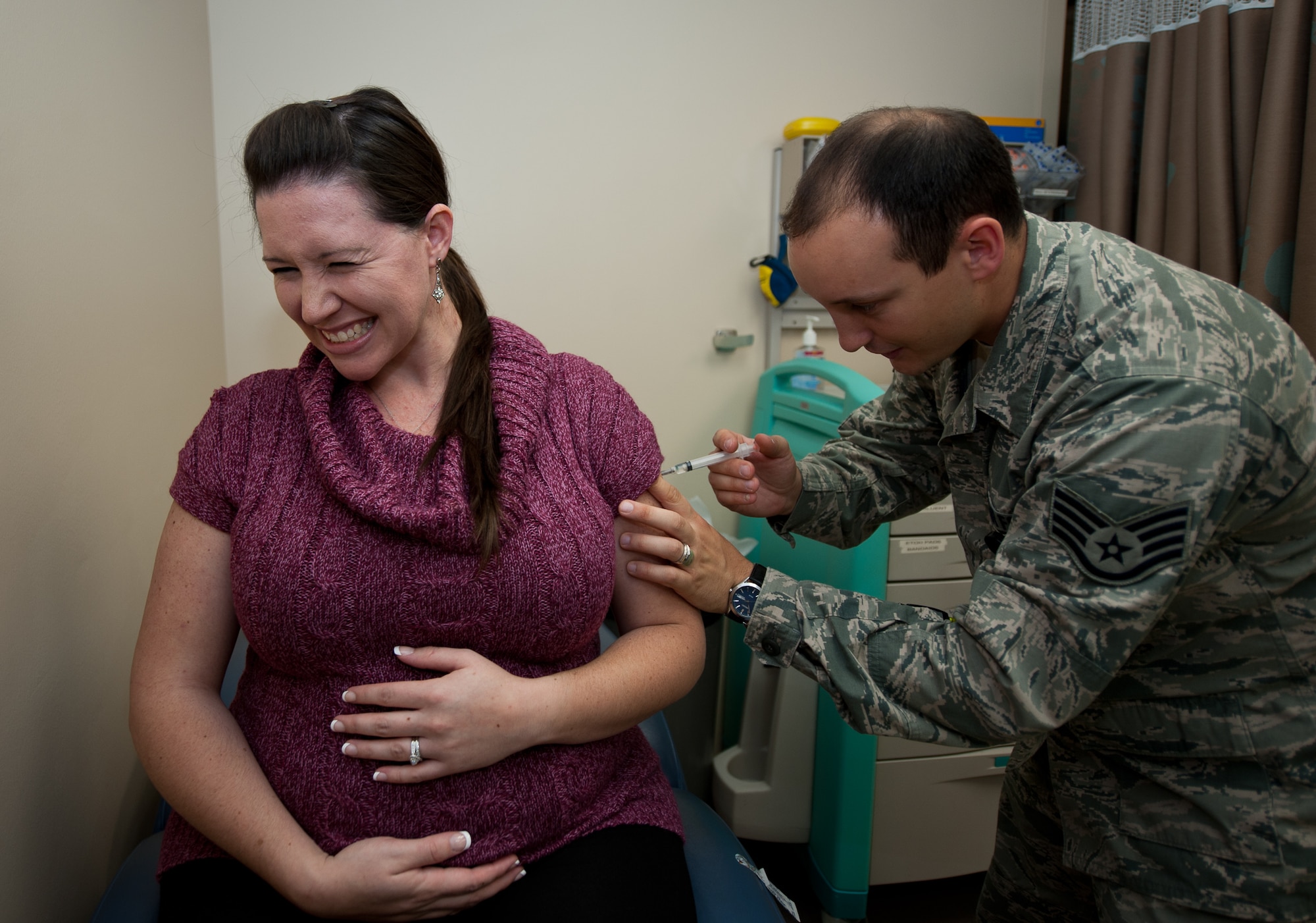 Staff Sgt. Jesse Lownds, 432nd Attack Squadron medical element, issues a flu vaccination to Kamaliah Scally, wife of Staff Sgt. Stephen Scally, 28th Security Forces Squadron security response leader, at Ellsworth Air Force Base, S.D., Oct. 3, 2013. An annual influenza vaccine is the first and most important step in protecting Airmen, families and civilians against flu viruses. (U.S. Air Force photo by Airman 1st Class Alystria Maurer/Released)