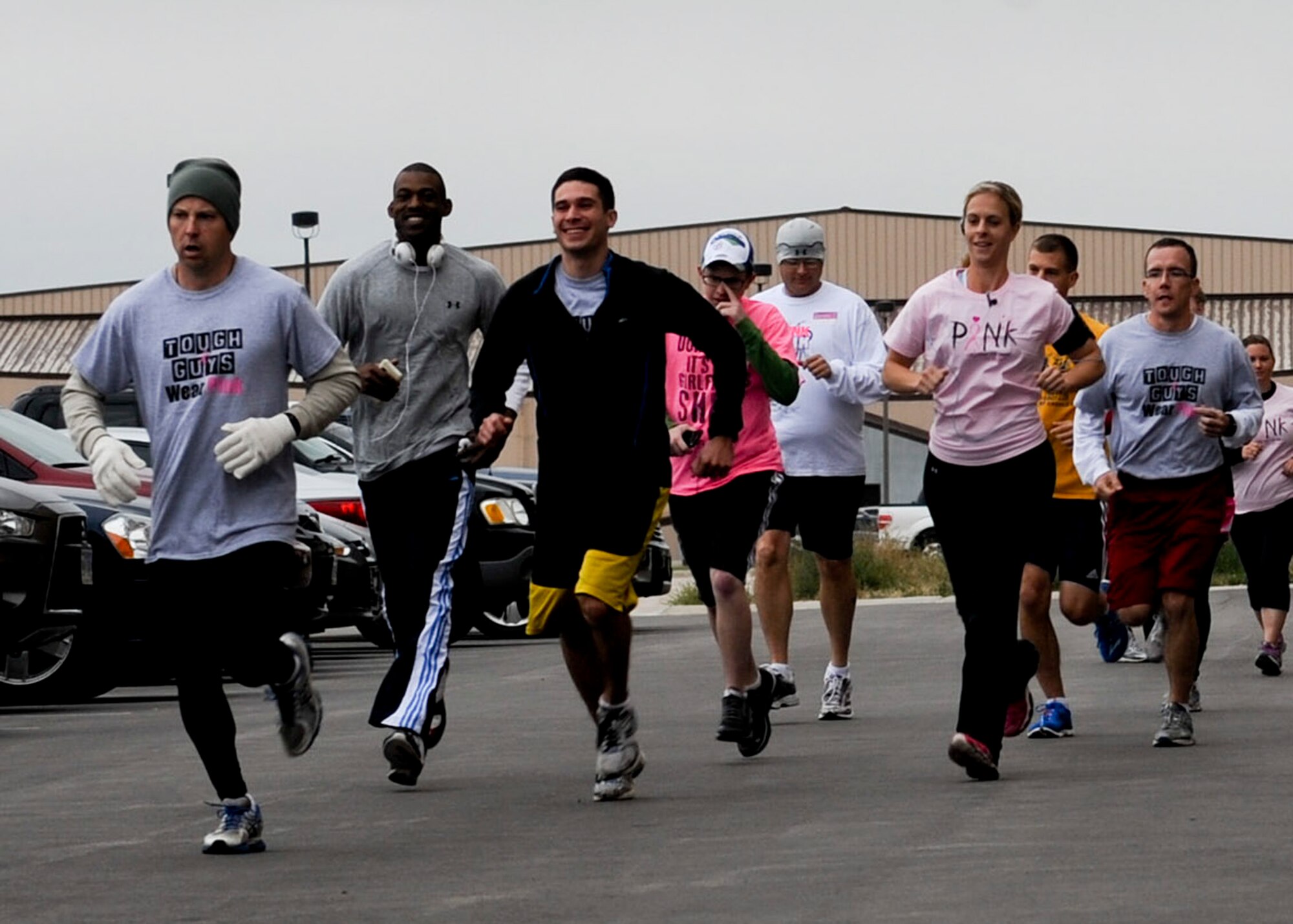 Runners of all ages and walks of life sprint past the starting point during the Think Pink Breast Cancer Awareness 5k run/1.5 mile walk at Ellsworth Air Force Base, S.D., Oct. 3, 2013. Approximately 76 people participated in the event, showing their support to breast cancer survivors and helping to bolster awareness of breast cancer. (U.S. Air Force photo by Senior Airman Anania Tekurio/Released) 