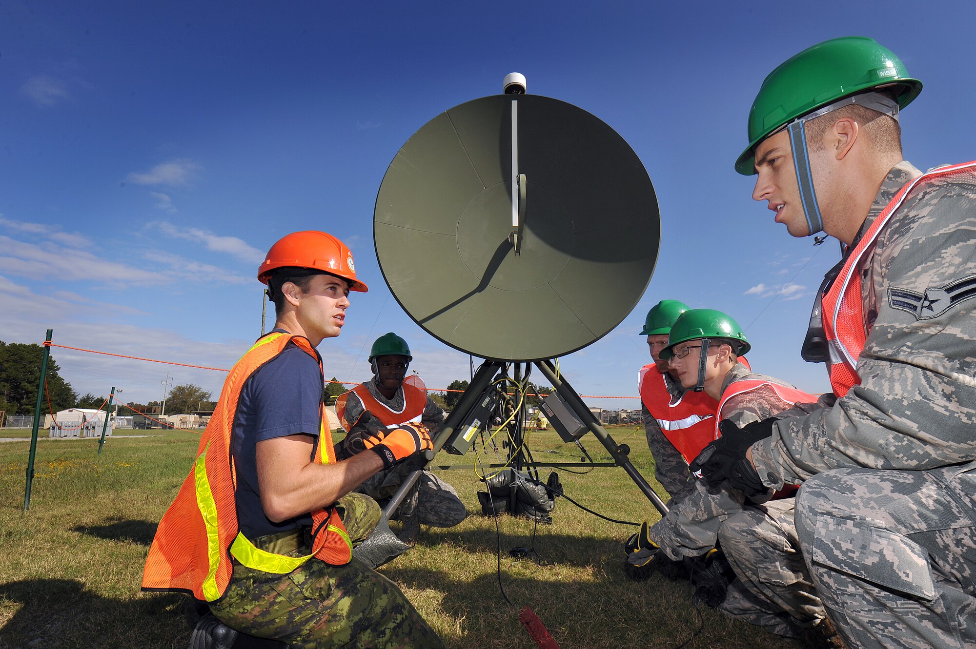 Royal Canadian Air Force Cpl. David Erazola, 8 Air Communications Control Squadron common ground entry technician, talks to 5th Combat Communications Group Airman about aligning a STINGER antenna. The antenna delivers real-time full-motion video for situational awareness, targeting, battle damage assessment, surveillance, convoy operations and other situations where eyes-on-target is required.  (U.S. Air Force photo by Tommie Horton)