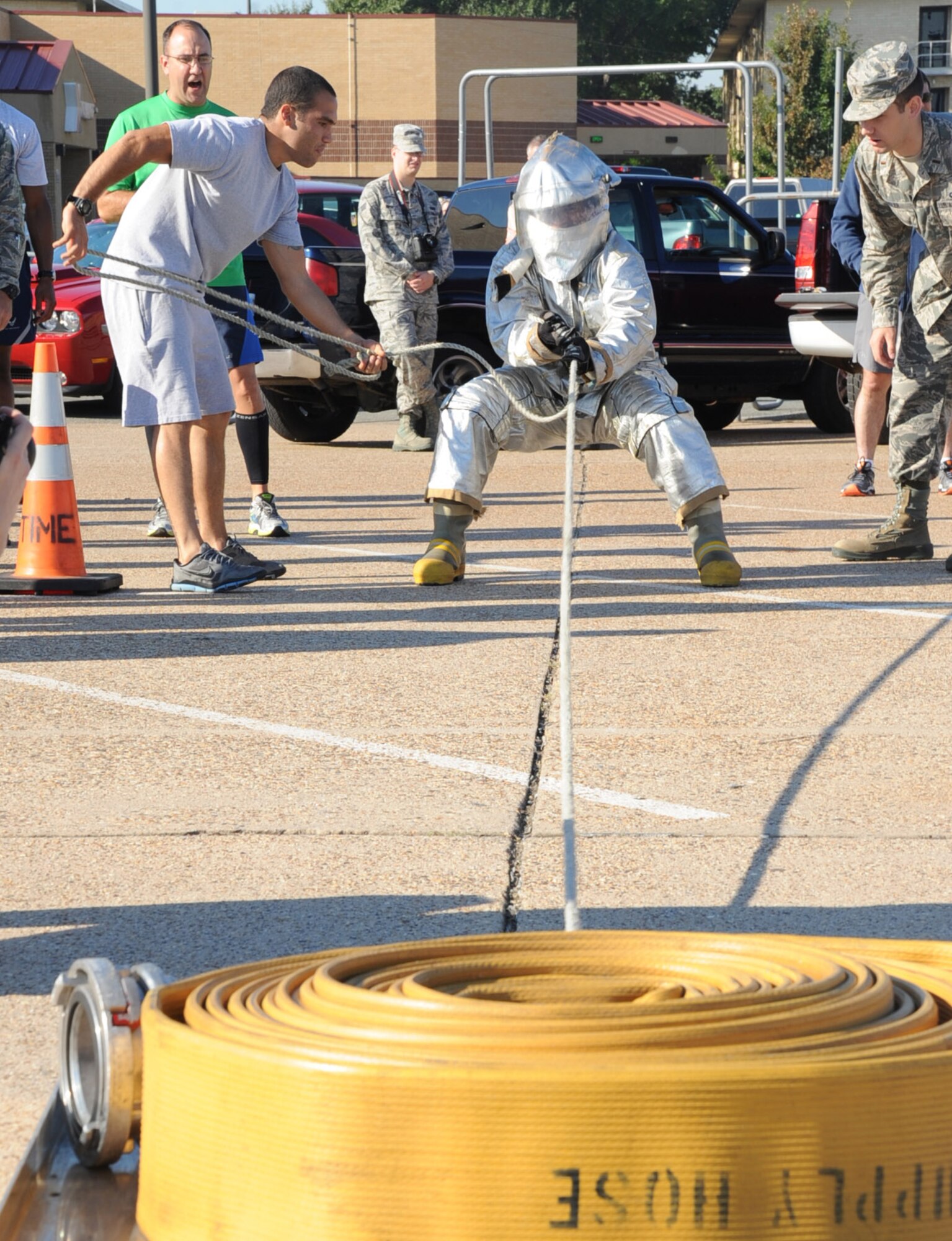 An Airman performs a hose drag during the third annual Fire Muster Challenge as part of Fire Prevention Week on Barksdale Air Force Base, La., Oct. 10, 2013. Enlisted members from the 2nd Civil Engineer Squadron won the challenge with a time of 2:41. (U.S. Air Force photo/Senior Airman Sean Martin)