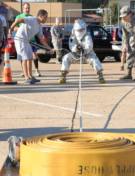 An Airman performs a hose drag during the third annual Fire Muster Challenge as part of Fire Prevention Week on Barksdale Air Force Base, La., Oct. 10, 2013. Enlisted members from the 2nd Civil Engineer Squadron won the challenge with a time of 2:41. (U.S. Air Force photo/Senior Airman Sean Martin)