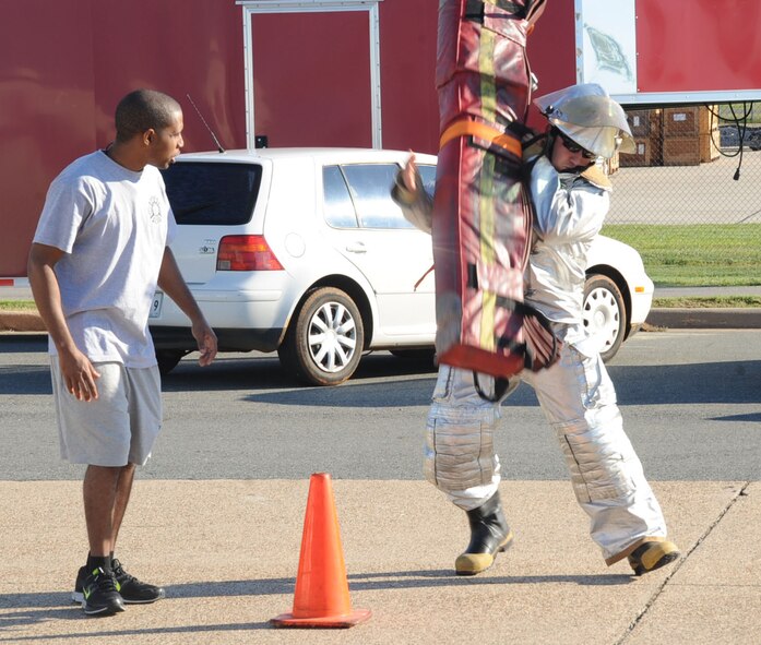 Airman 1st Class Buck Taylor, 2nd Civil Engineer Squadron explosive ordnance disposal technician, performs a hotel pack carry during the third annual Fire Muster Challenge as part of Fire Prevention Week on Barksdale Air Force Base, La., Oct. 10, 2013. A hotel pack carry is a technique used to fight fires in a multiple level facility. (U.S. Air Force photo/Senior Airman Sean Martin)