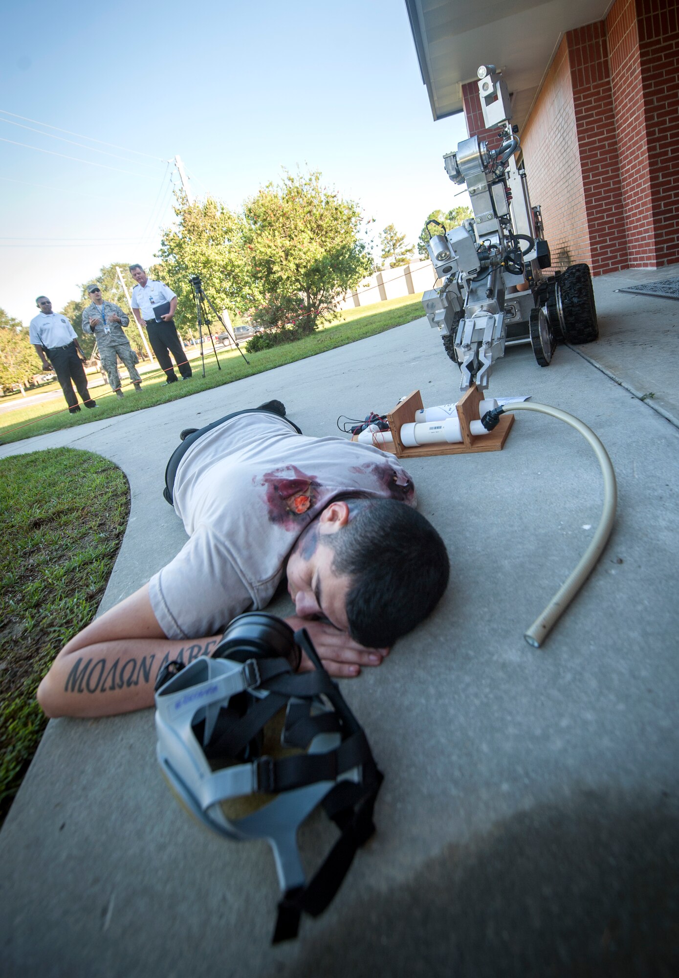 An Airman plays the role of the dead perpetrator during a major accident response exercise at Moody Air Force Base, Ga., Sept. 27, 2013. The perpetrator was killed from skin burns, despite wearing a gas mask, when he set off a chlorine gas device in the building and ran out.  (U.S. Air Force photo by Senior Airman Jarrod Grammel/Released)
