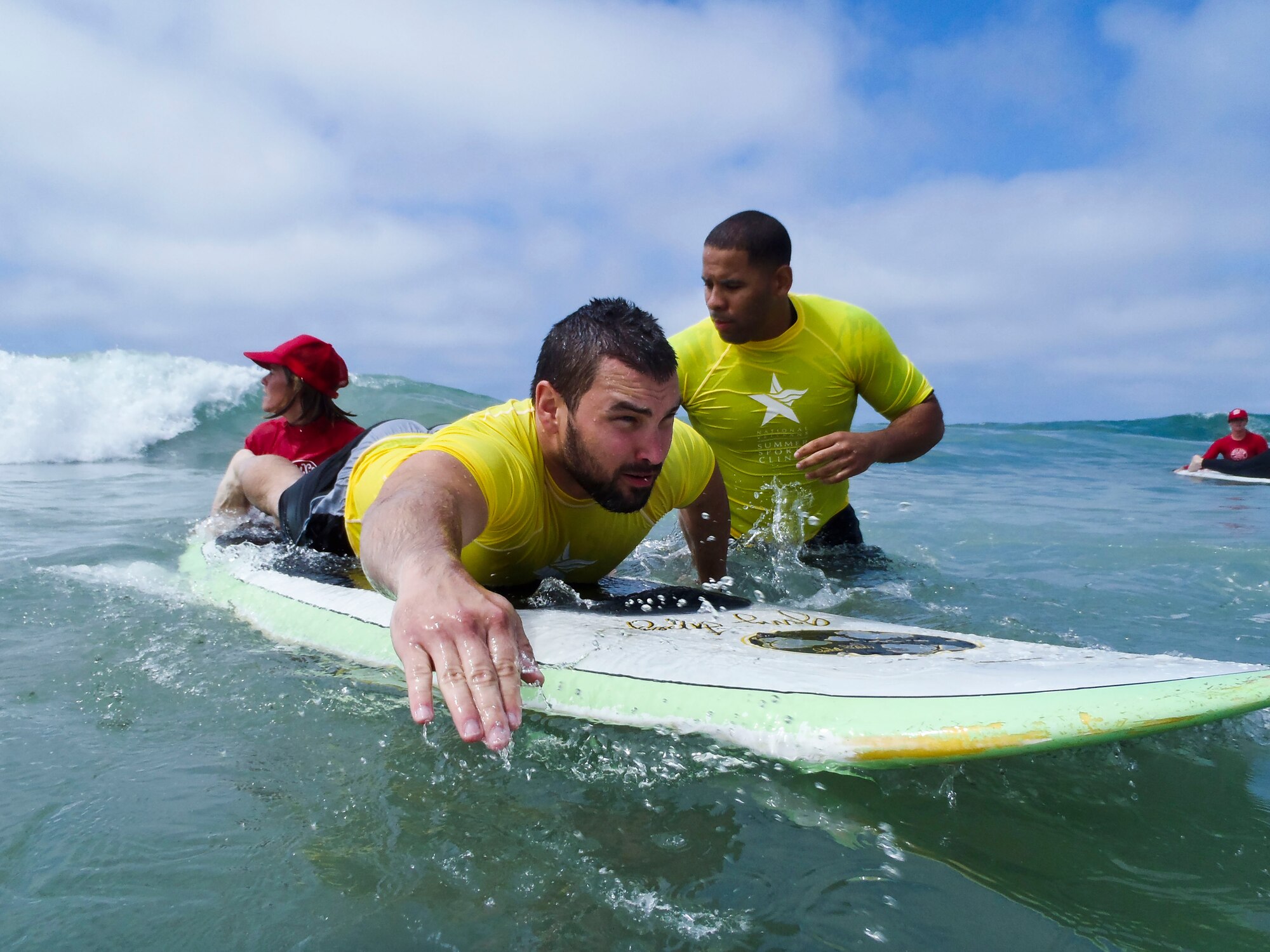 Retired Army Staff Sgt. Jeremy Henderson paddles in as he prepares to ride a wave during the National Disabled Veterans Summer Sports Clinic, which took place Sept. 12 through 22 in San Diego. The clinic provided opportunities for veterans to learn adaptive surfing, sailing, cycling, kayaking, rowing, judo and archery. More than 40 Luke Airmen volunteered to help at the clinic. (U.S. Air Force photo/Senior Airman David Owsianka)