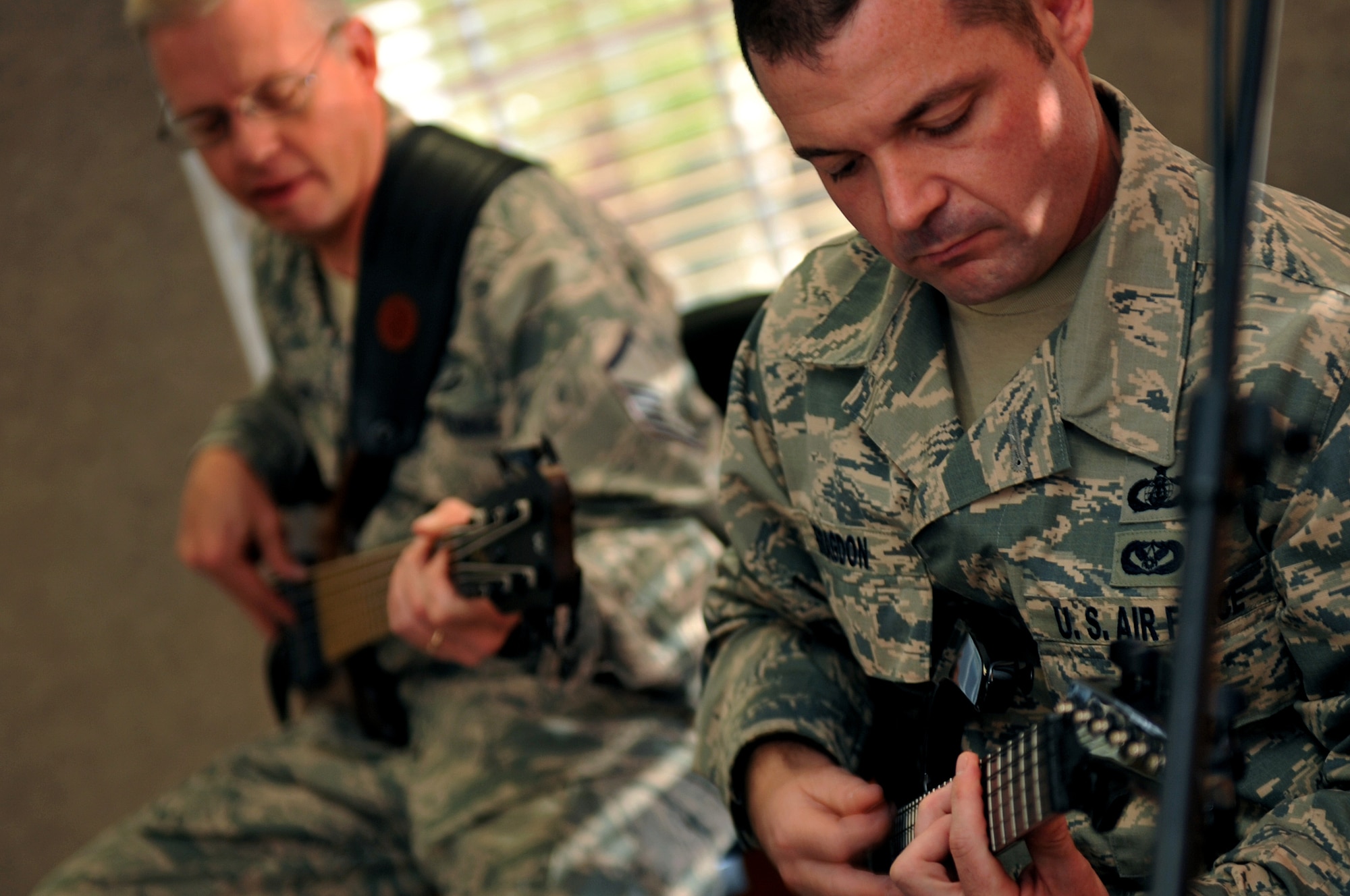 U.S. Air Force Tech. Sgt. Dan Bragdon, a guitarist for the Heartland of America Band, plays closely alongside U.S. Air Force Master Sgt. Gary Olson, on bass guitar in the background, during a band rehearsal Oct. 10, on Offutt Air Force Base, Neb. The HOAB has been around now for more than 70 years. (U.S. Air Force photo by Jeff W. Gates/Released)