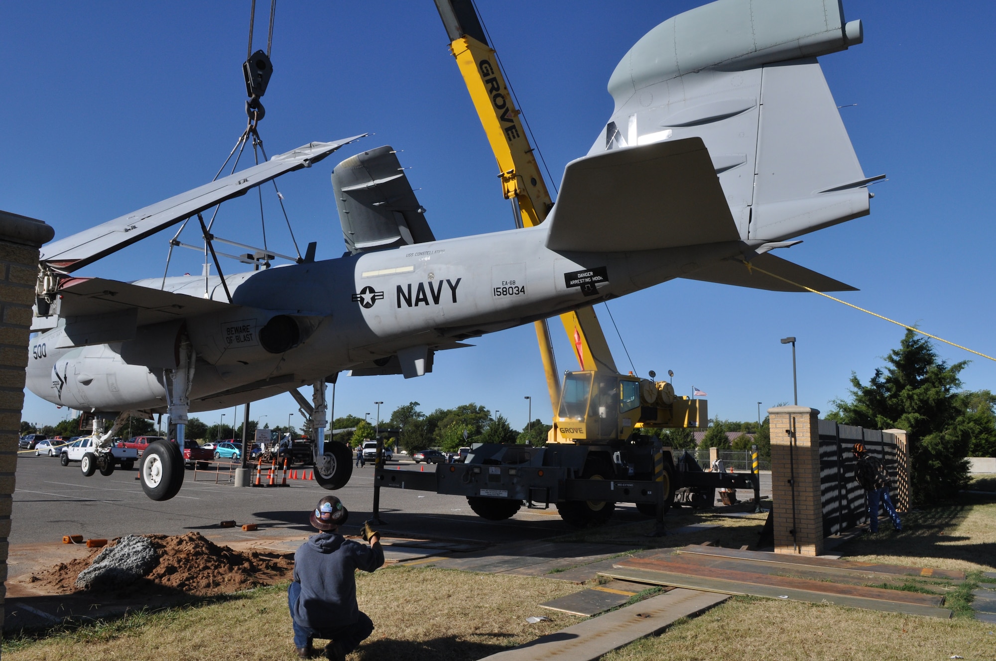 Joshua Harvey of the 566th Aircraft Maintenance Squadron Servicing Section watches as crane operator Michael Youngberg weighs the Prowler before moving it into the airpark. Even without its two J52-P408 turbofan jet engines and its avionics, which had previously been removed, the Prowler still weighed 25,000 pounds. (Air Force photo by April McDonald)