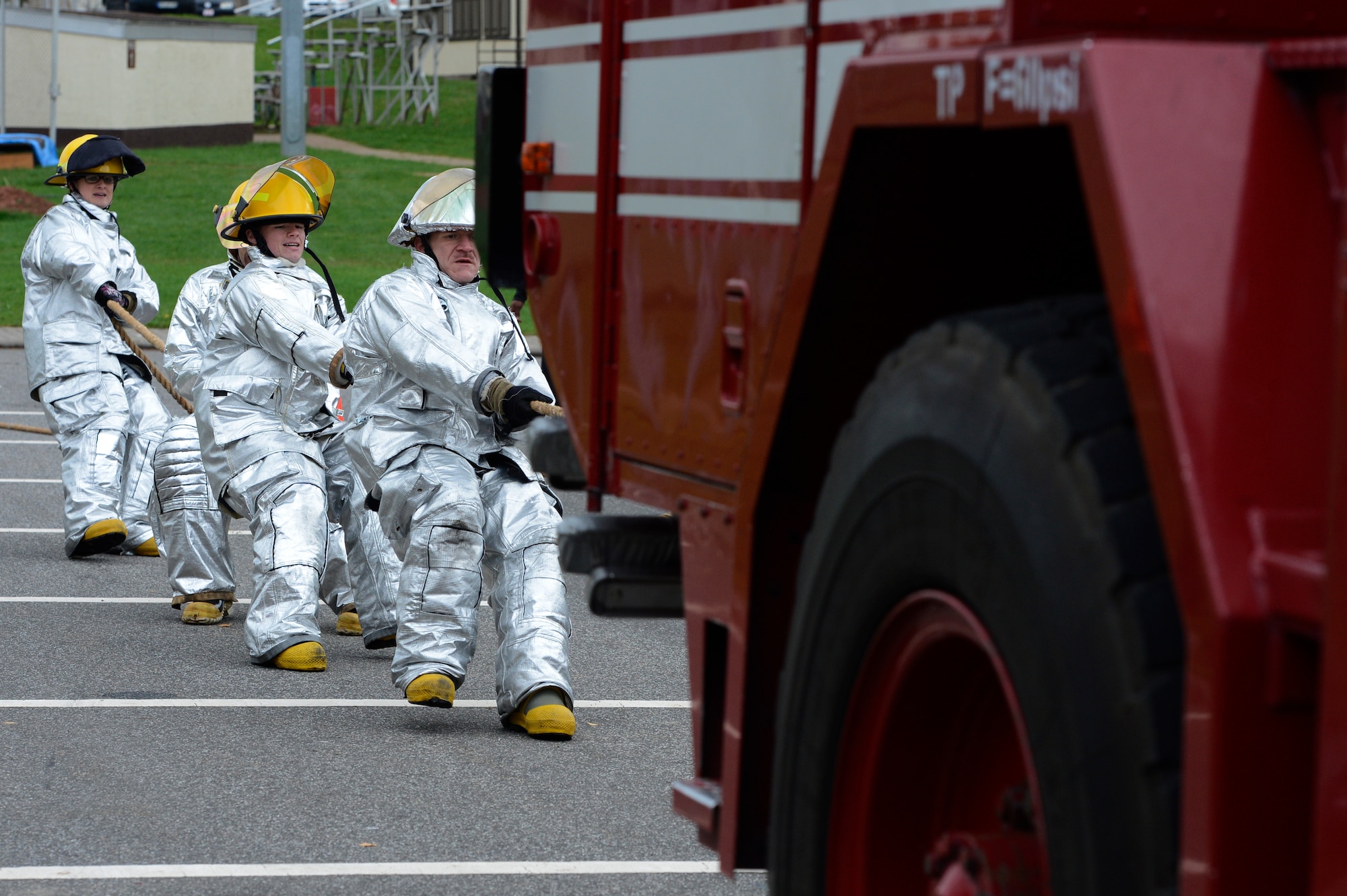 SPANGDAHLEM AIR BASE, Germany – The 52nd Equipment Maintenance Squadron team hauls a P-19 fire truck more than 20 feet during the last obstacle of the Spangdahlem Fire Prevention Week fire muster event Oct. 10, 2013. The P-19 holds 1,000 gallons of water, 130 gallons of foam and 500 pounds of dry chemical agent. Firefighters can spray water and foam at the same time to extinguish a fire. (U.S. Air Force photo by Staff Sgt. Christopher Ruano/Released)
