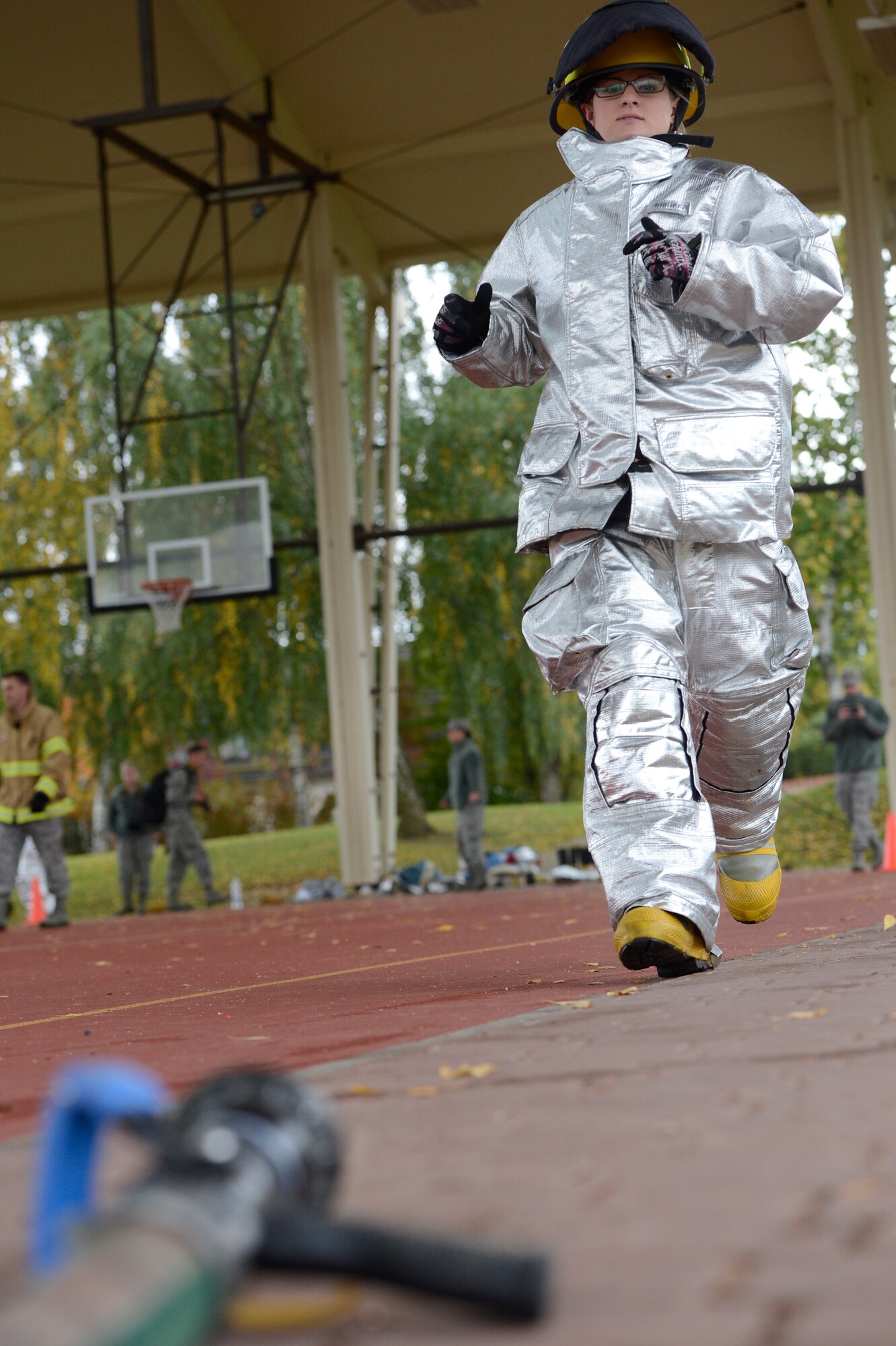 SPANGDAHLEM AIR BASE, Germany – U.S. Air Force Senior Airman Katelyn Camacho, 52nd Equipment Maintenance Squadron phase support technician, darts to the charged handline during the Spangdahlem Fire Prevention Week fire muster event Oct. 10, 2013. The handline was carried more than 30 feet and sprayed to knock over cones with a jet stream of water simulating putting out a fire. The 52nd EMS team came in first place for the event. (U.S. Air Force photo by Staff Sgt. Christopher Ruano/Released)