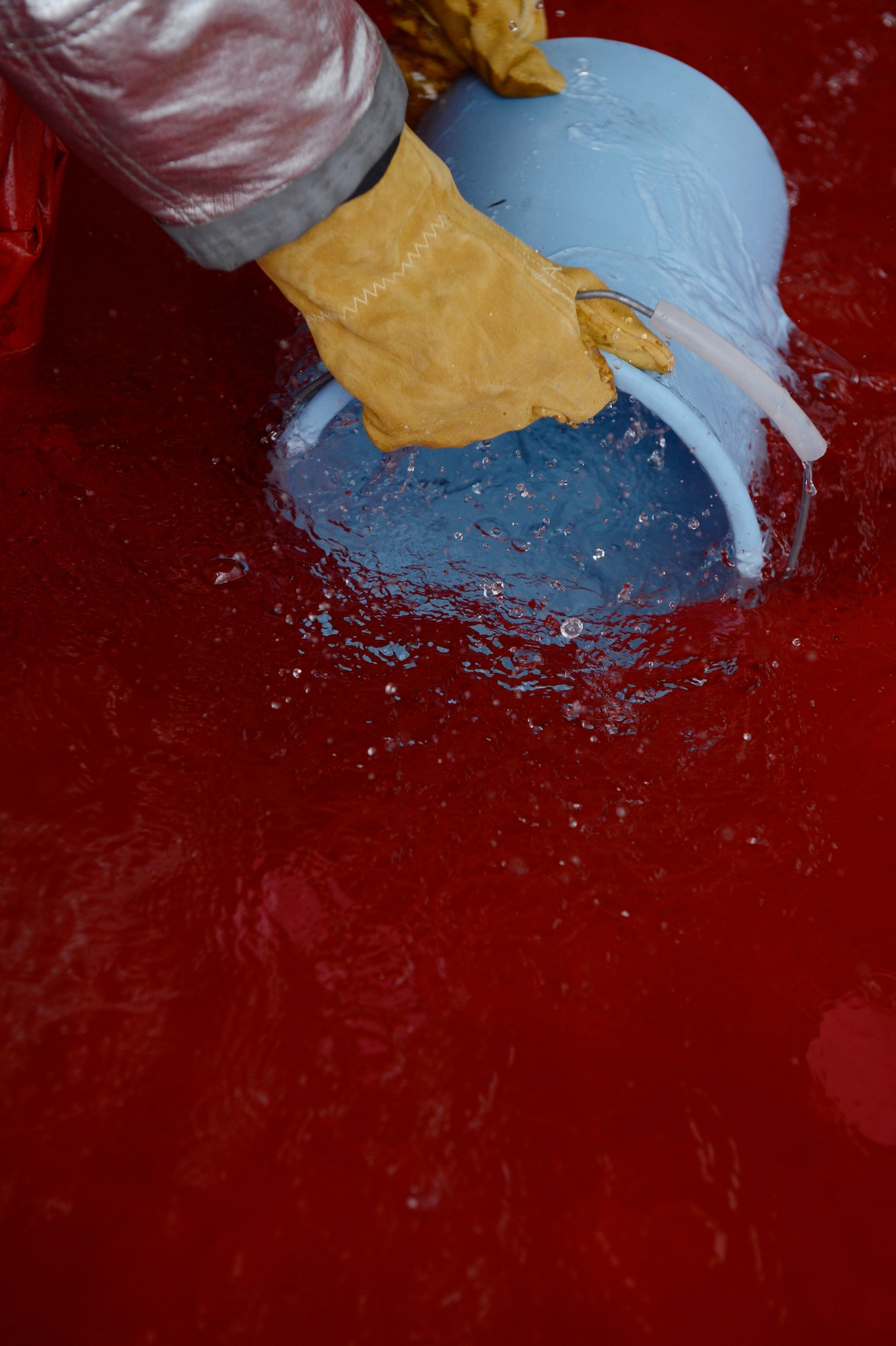 SPANGDAHLEM AIR BASE, Germany – U.S. Air Force 2nd Lt. Steven Milligan, 52nd Logistics Readiness Squadron material management flight commander, shovels water into a bucket to put out a simulated fire during the Spangdahlem Fire Prevention Week fire muster challenge Oct. 10, 2013. The bucket brigade portion of the fire muster obstacle course consisted of all four team members collecting water to extinguish the fire before advancing to the next obstacle. (U.S. Air Force photo by Staff Sgt. Christopher Ruano/Released)