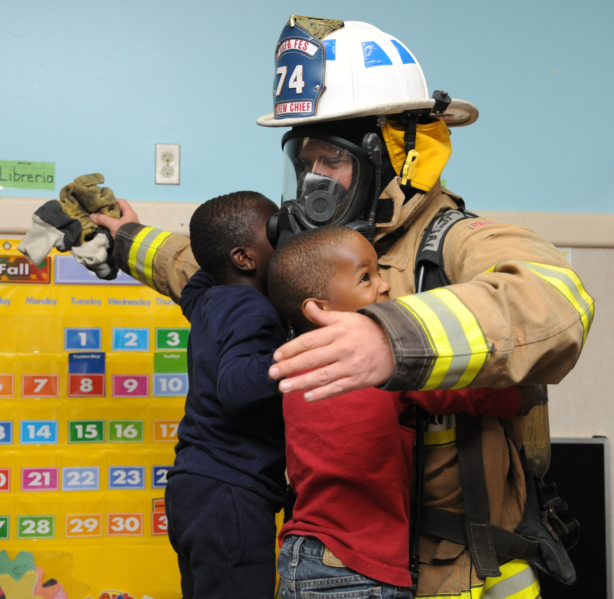 A Team Andrews fireman hugs children two at the child development center at Joint Base Andrews, Md., Oct. 10, 2013. Firefighters made an appearance to educate the children about fire safety during National Fire Prevention Week. (U.S. Air Force photo/Airman 1st Class Joshua R. M. Dewberry) 