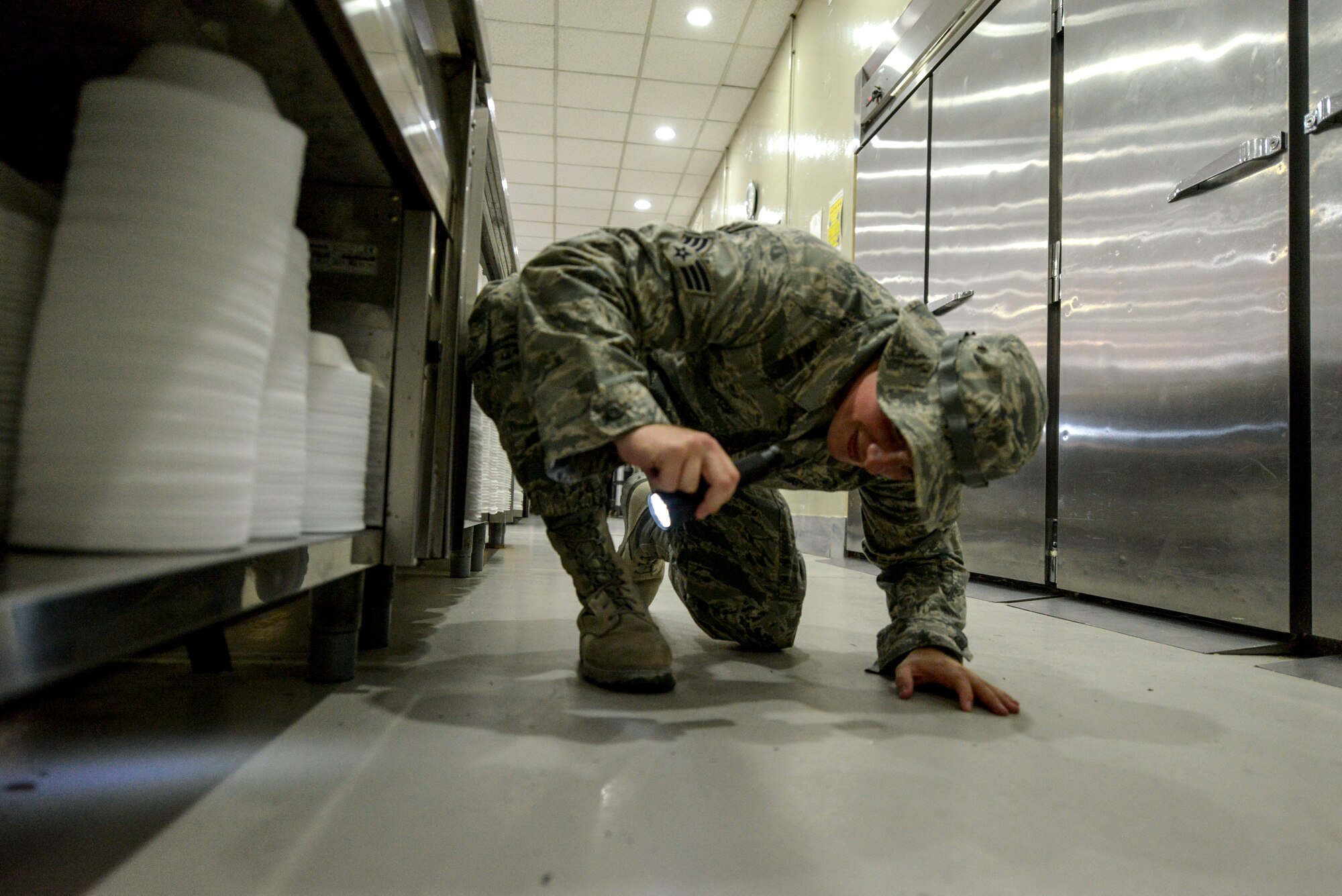 Senior Airman Jordan Hocker inspects for pests in the dining facility at the 379th Air Expeditionary Wing in Southwest Asia, Oct. 8, 2013. Pest management Airmen perform random inspections base wide to assure quality conditions. Hocker is a 379th Expeditionary Civil Engineer Squadron pest management journeyman deployed from Ramstein Air Base, Germany, and hails from Indianapolis. (U.S. Air Force photo/Tech. Sgt. Joselito Aribuabo)