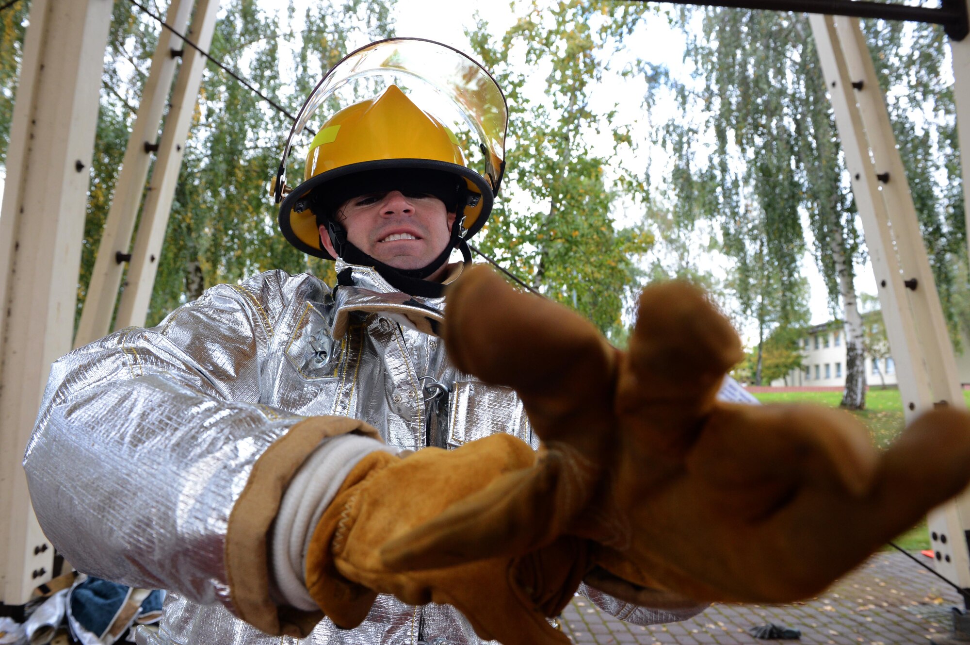 SPANGDAHLEM AIR BASE, Germany – U.S. Air Force Staff Sgt. Christopher Ruano, 52nd Fighter Wing Public Affairs photojournalist from Phoenix, puts on his gloves during a fire muster competition Oct. 10, 2013. At the start on the competition, Ruano was required to put on fire gear as quickly as he could before proceeding to the next challenge. Ruano and his team completed the fire muster with a total time of 6:15 placing 2nd overall. (U.S. Air Force photo by Airman 1st Class Kyle Gese/Released)