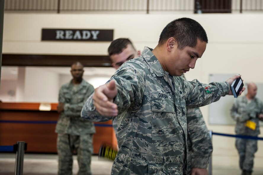 Tech Sgt. Shawn Gumabon, 39th Communications Squadron information technology asset management NCO in charge, walks through a metal detector during a noncombatant evacuation operation exercise Sept. 27, 2013, at Incirlik Air Base, Turkey.  The NEO program is a Department of Defense requirement for all base commanders to develop plans for evacuating people from their installations in the event of natural disasters. (U.S. Air Force photo by Airman 1st Class Nicole Sikorski) 