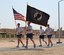 Airmen run with the U.S. flag and the National League of Families prisoner of war and missing in action flag during a 24-hour POW/MIA vigil walk at the 64th Air Expeditionary Group in Southwest Asia, Sept. 20, 2013. Participants volunteered for one-hour blocks, rotating the flags amongst themselves for a time. Many groups stayed longer or returned for a second round. (U.S. Air Force photo / Master Sgt. Dale Sickels)