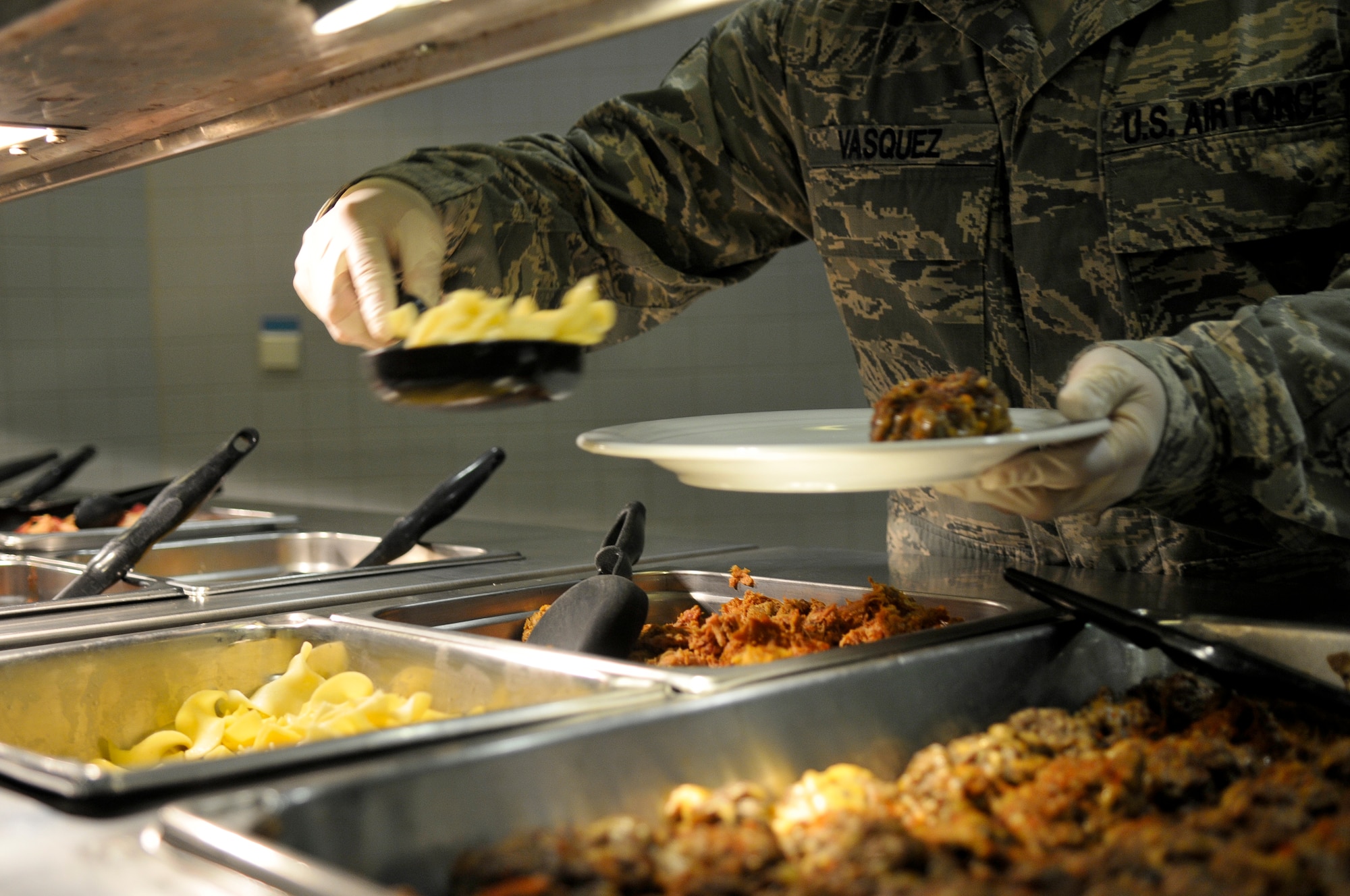 Staff Sgt. Ruben Vasquez, 786th Force Support Squadron food service supervisor, serves food onto a plate Oct. 7, 2013, Ramstein Air Base, Germany. Rhineland Inn Dining Facility Airmen work around-the-clock in order to ensure customers have healthy meal options available four times daily. (U.S. Air Force photo/Senior Airman Jose L. Leon)