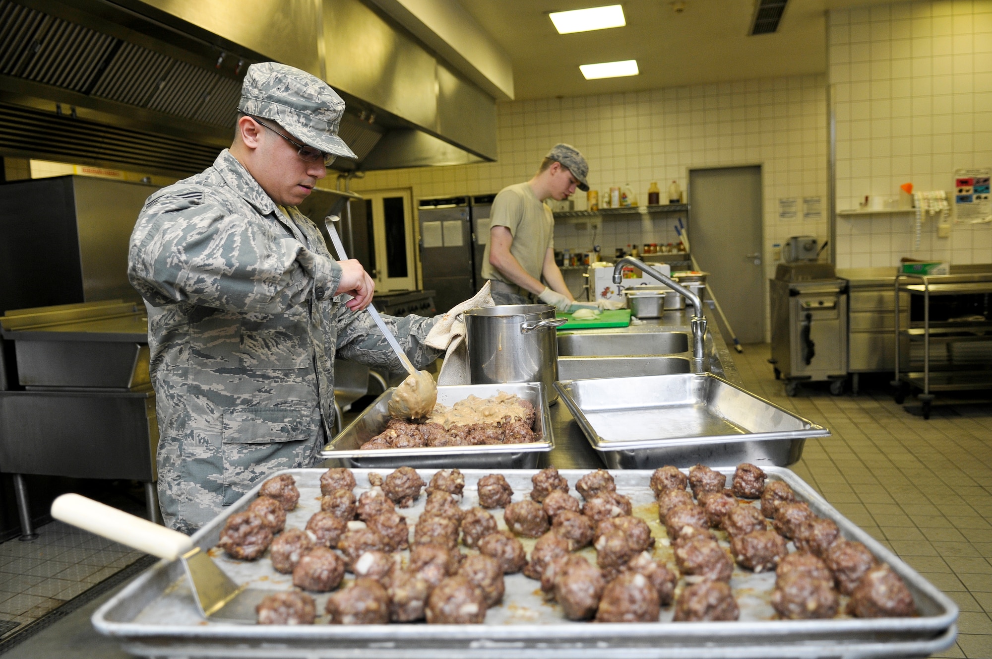 Staff Sgt. Ruben Vasquez, 786th Force Support Squadron food service supervisor, pours gravy onto meatballs, Oct. 7, 2013, Ramstein Air Base, Germany. The Rhineland Inn Dining Facility offers four meals a day in order to provide a low-budget meal option for Airmen working around-the-clock shifts. (U.S. Air Force photo/Senior Airman Jose L. Leon)