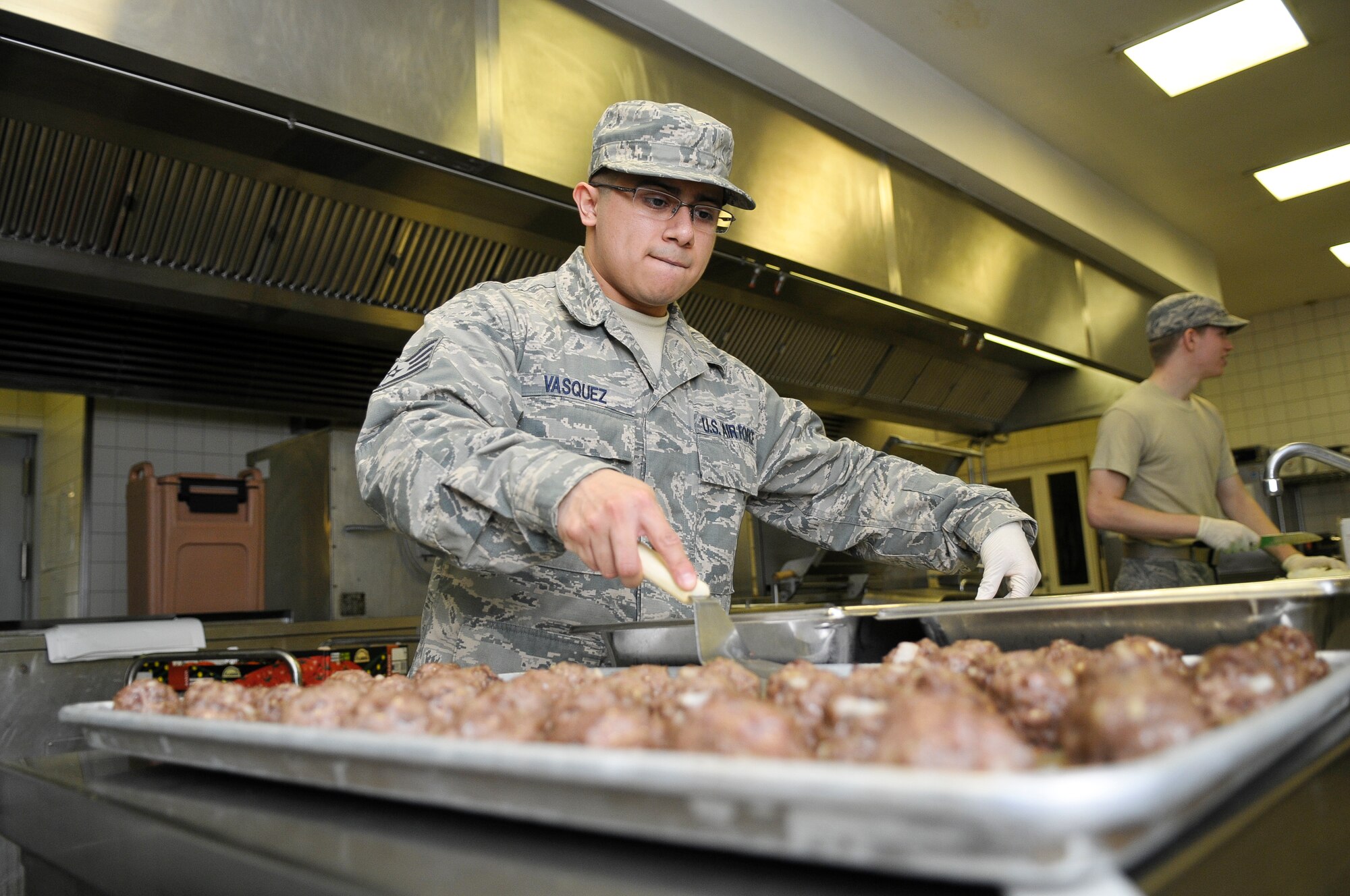 Staff Sgt. Ruben Vasquez, 786th Force Support Squadron food service supervisor, removes meatballs from a baking sheet, Oct. 7, 2013, Ramstein Air Base, Germany. The Rhineland Inn Dining Facility offers four meals a day in order to provide a low-budget meal option for Airmen working around-the-clock shifts. (U.S. Air Force photo/Senior Airman Jose L. Leon)