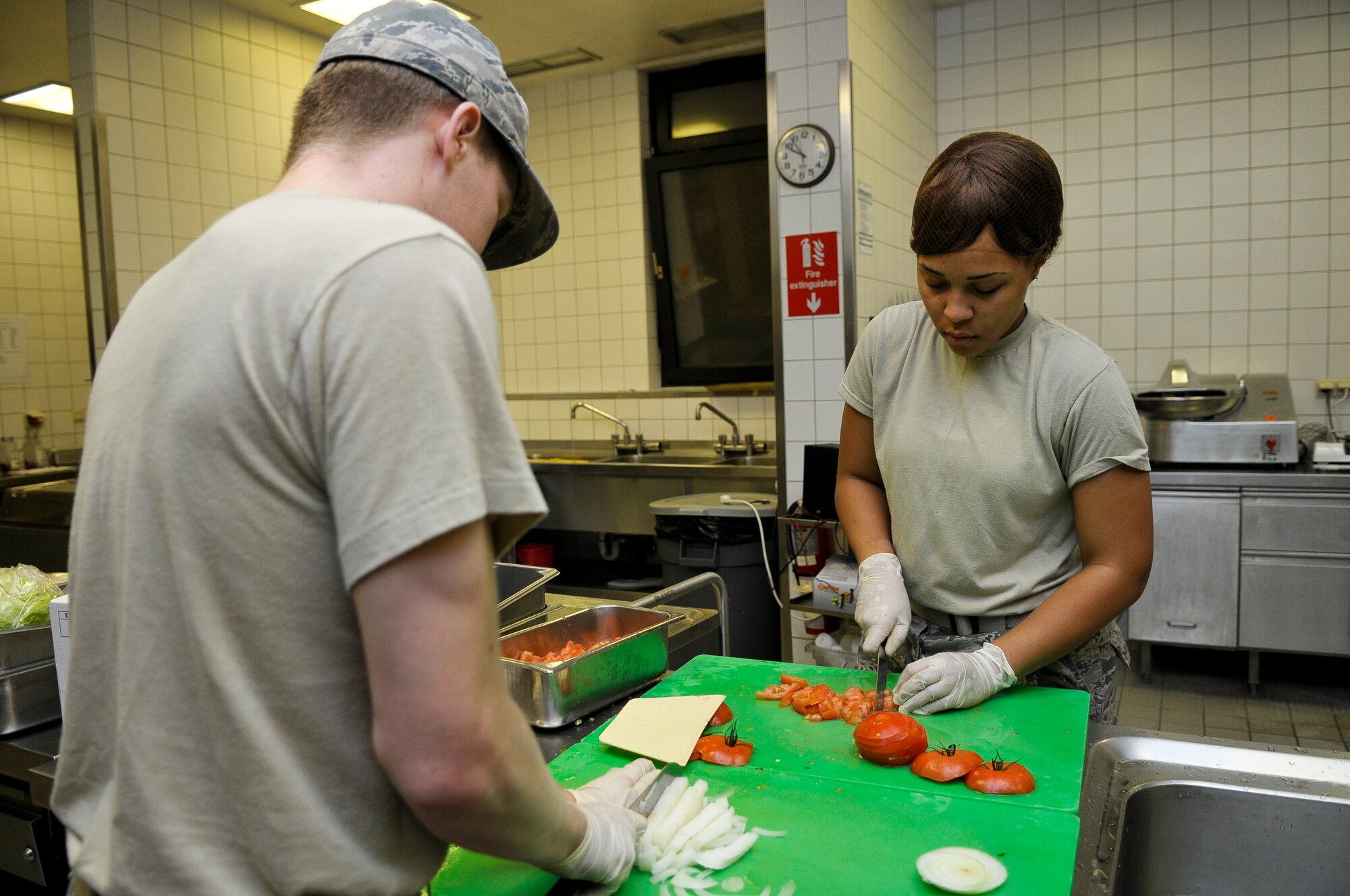 Airman 1st Class Austin Ballinger and Airman Savannah West, 786th Force Support Squadron food services technicians, prepare vegetables for midnight chow, Oct. 7, 2013, Ramstein Air Base, Germany. The Airmen of the Rhineland Inn Dining Facility play an important part in deciding what healthy choices are offered. (U.S. Air Force photo/Senior Airman Jose L. Leon)