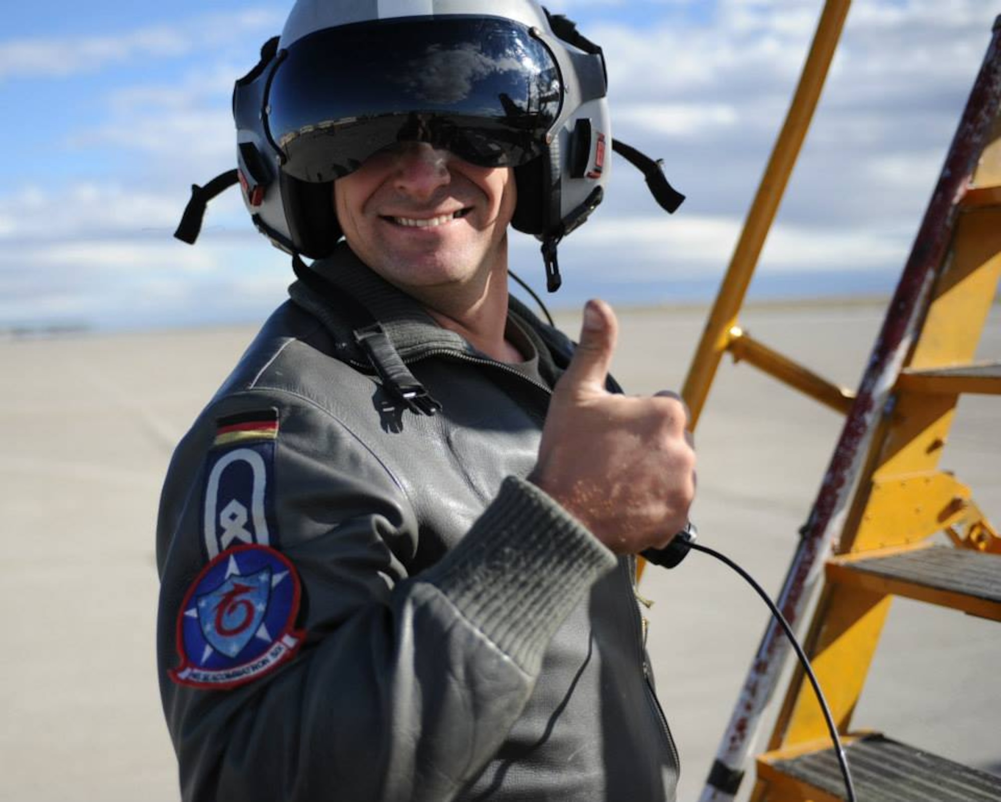 A German Air Force crewchief gives a thumbs-up, as fellow GAF pilots return from a mission where they dropped training bombs as close-air support, assisting 1st Air Naval Gunfire Liaison Company joint terminal attack controller U.S. Marines, who were assaulting a mock village at Saylor Creek Bomb Range, about 60 miles from Mountain Home Air Force Base, Idaho, Oct. 4, 2013. Many of those same Germans and their Canadian an U.S. servicemember allies will celebrate Oktoberfest in Mountain Home today. (U.S. Air Force photo by Senior Airman Benjamin Sutton/RELEASED)