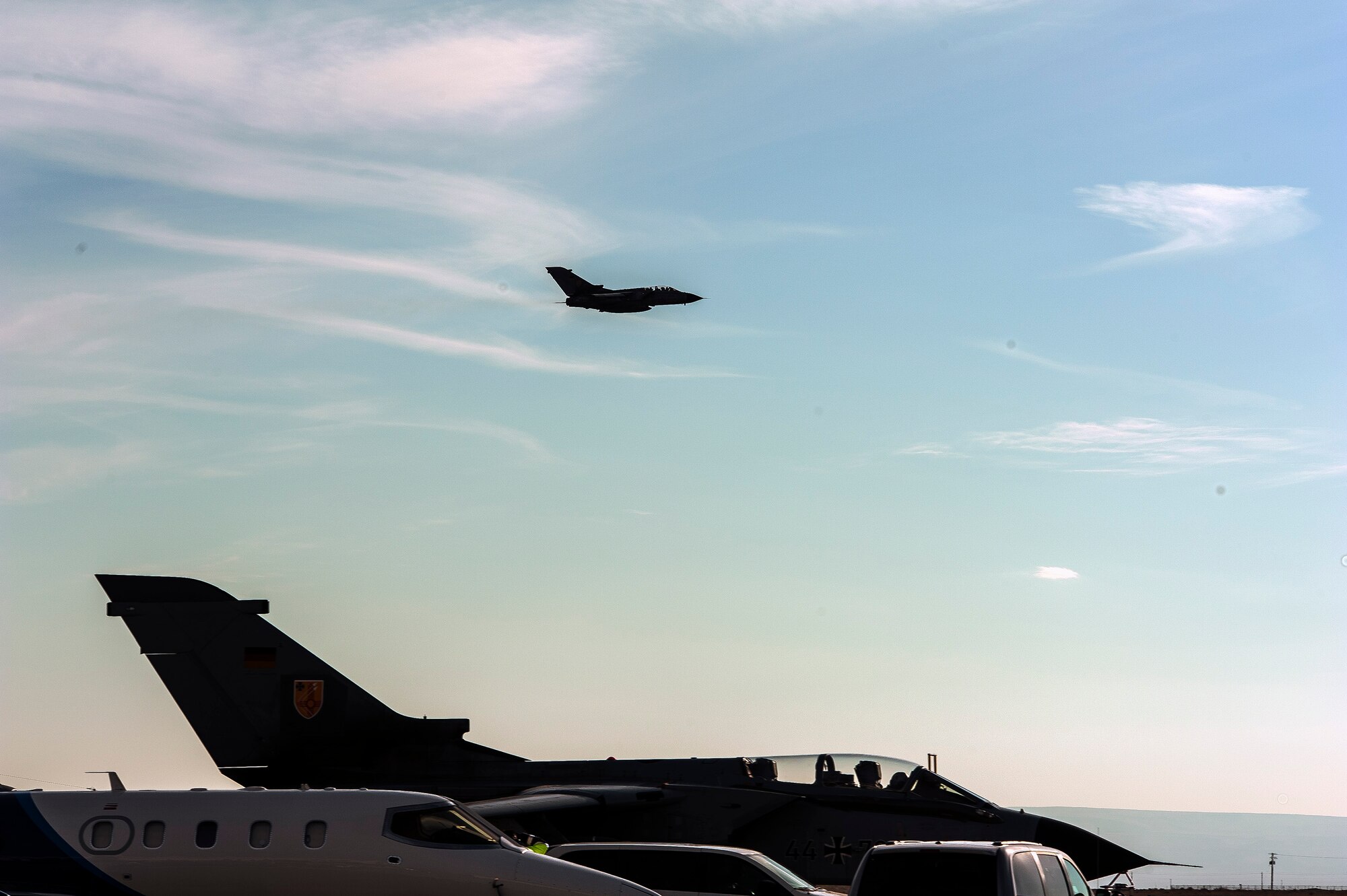 A German Air Force AG-51 Tornado flies over the runway at Mountain Home Air Force Base, Idaho, as another Tornado and Luftwaffe Jamkite taxi toward their parking spots, Oct. 10, 2013, during exercise Mountain Roundup 2013. The exercise is part of the German Air Force Tornado Fighter Weapons Instructor Course Mission Employment Phase, and is scheduled to end Oct. 16. (U.S. Air Force photo by Master Sgt. Kevin Wallace)