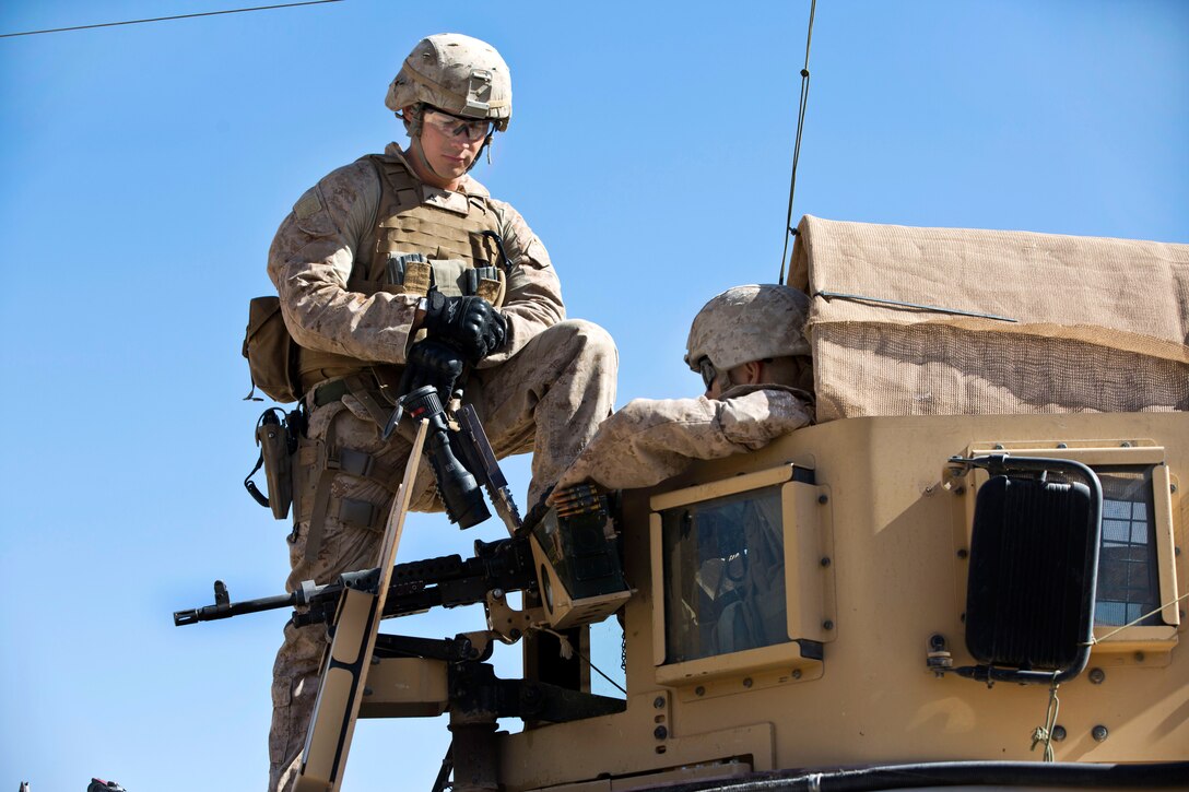 U.S. Marine Corps Lance Cpl. Stephen Johnson, left, instructs U.S. Marine Corps Lance Cpl. Christian Moore on his targets during a machine gun shoot in the Kajaki district in Afghanistan's Helmand province, Oct. 6, 2013. Johnson and Moore, machine gunners, are assigned to Lima Company, 3rd Battalion, 7th Marine Regiment.