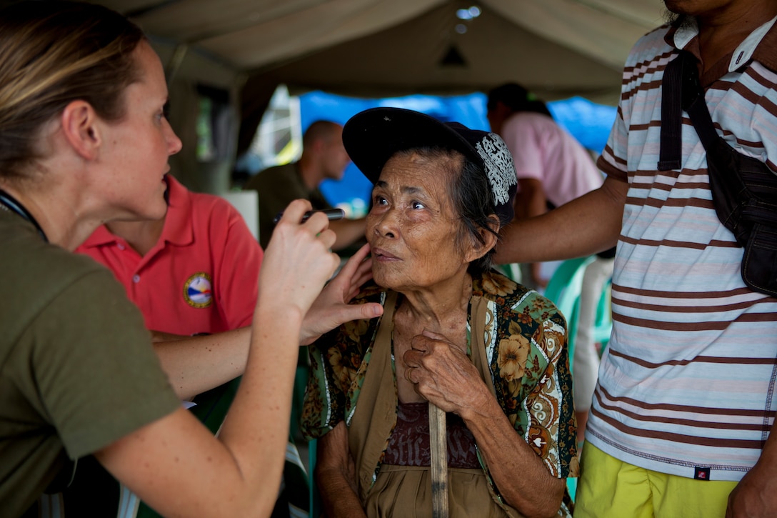 U.S. Navy Lt. Stephanie Ellis, left, examines a Filipino woman during a cooperative health event in Victory Village, Legazpi, Albay province, Philippines, Oct. 1, 2013. The event is part of Amphibious Landing Exercise 14. Ellis, a family practitioner, is assigned to Marine Corps 3rd Medical Battalion.