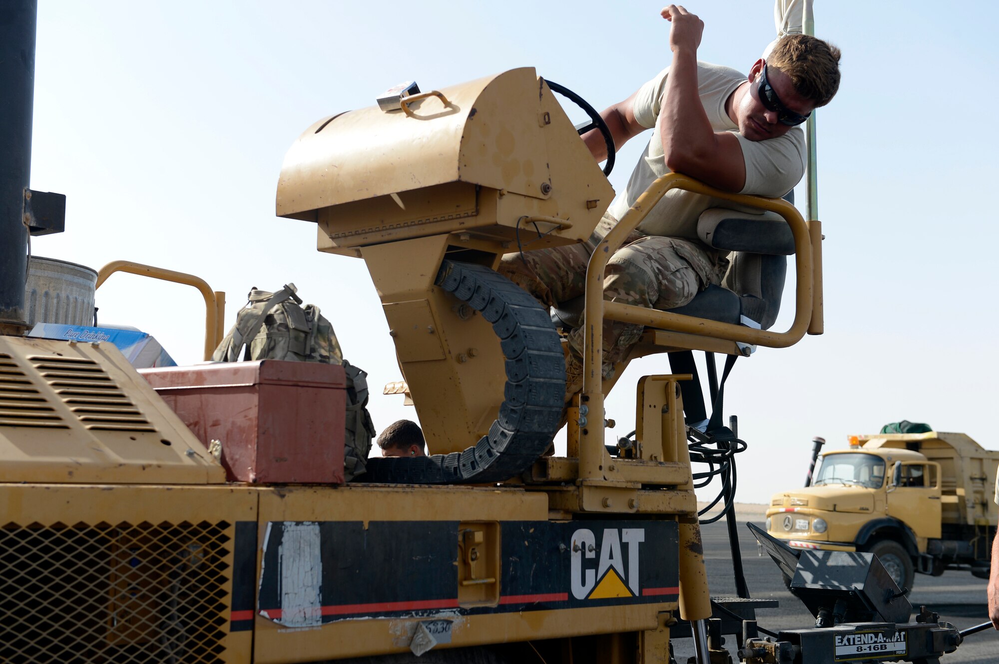Staff Sgt. Jeremy Coates, 557th Expeditionary Red Horse Squadron, heavy equipment operator, operates an asphalt paver here, Oct. 3, 2013.  Coates is monitoring the lines to ensure there are no gaps in the new flight line aircraft parking area.  Coates, a native of Oxford, Mich., is deployed out of Malmstrom Air Force Base, Mont. (U.S. Air Force photo by Master Sgt. Christopher A. Campbell)