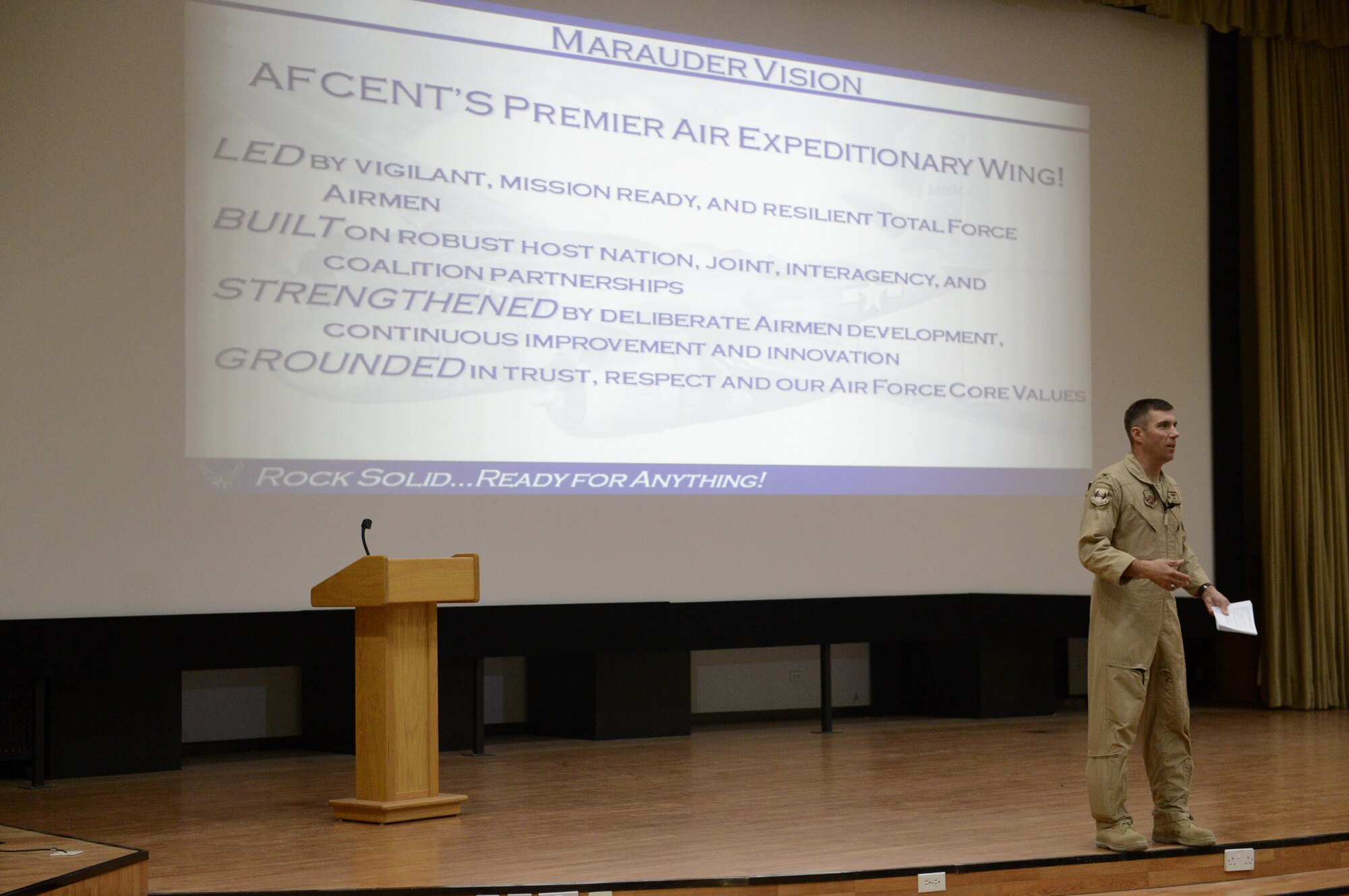 Col. John Klein, Jr.,  386th Air Expeditionary Wing commander, discusses the wing's mission and way ahead here, Sept. 30, 2013.  Klein held an all-call to discuss the wing's new mission, vision and priorities. Attendees were encouraged to bring their smart devices to vote on various topics aimed at assessing their understanding of the new mission, vision and priorities. (U.S. Air Force photo by Master Sgt. Christopher A. Campbell)