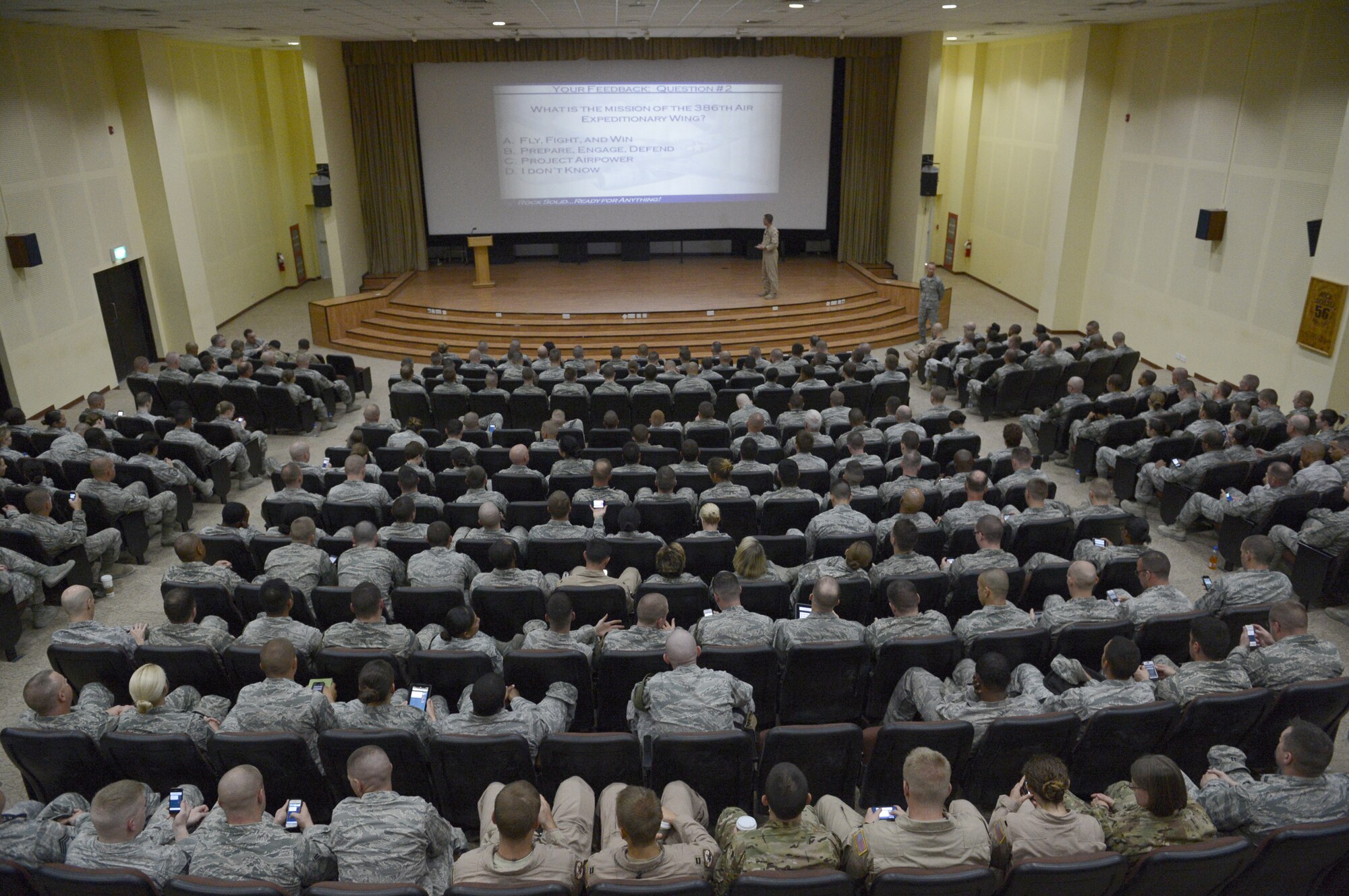 Members of the 386th Air Expeditionary Wing vote on their smart devices here, Sept. 30, 2013.  Col. John Klein, Jr., 386th Air Expeditionary Wing commander, held an all-call to discuss the wing's new mission, vision and priorities.  The all-call featured electronic voting on questions aimed at assessing the wing's understanding of the new mission, vision and priorities. (U.S. Air Force photo by Master Sgt. Christopher A. Campbell)