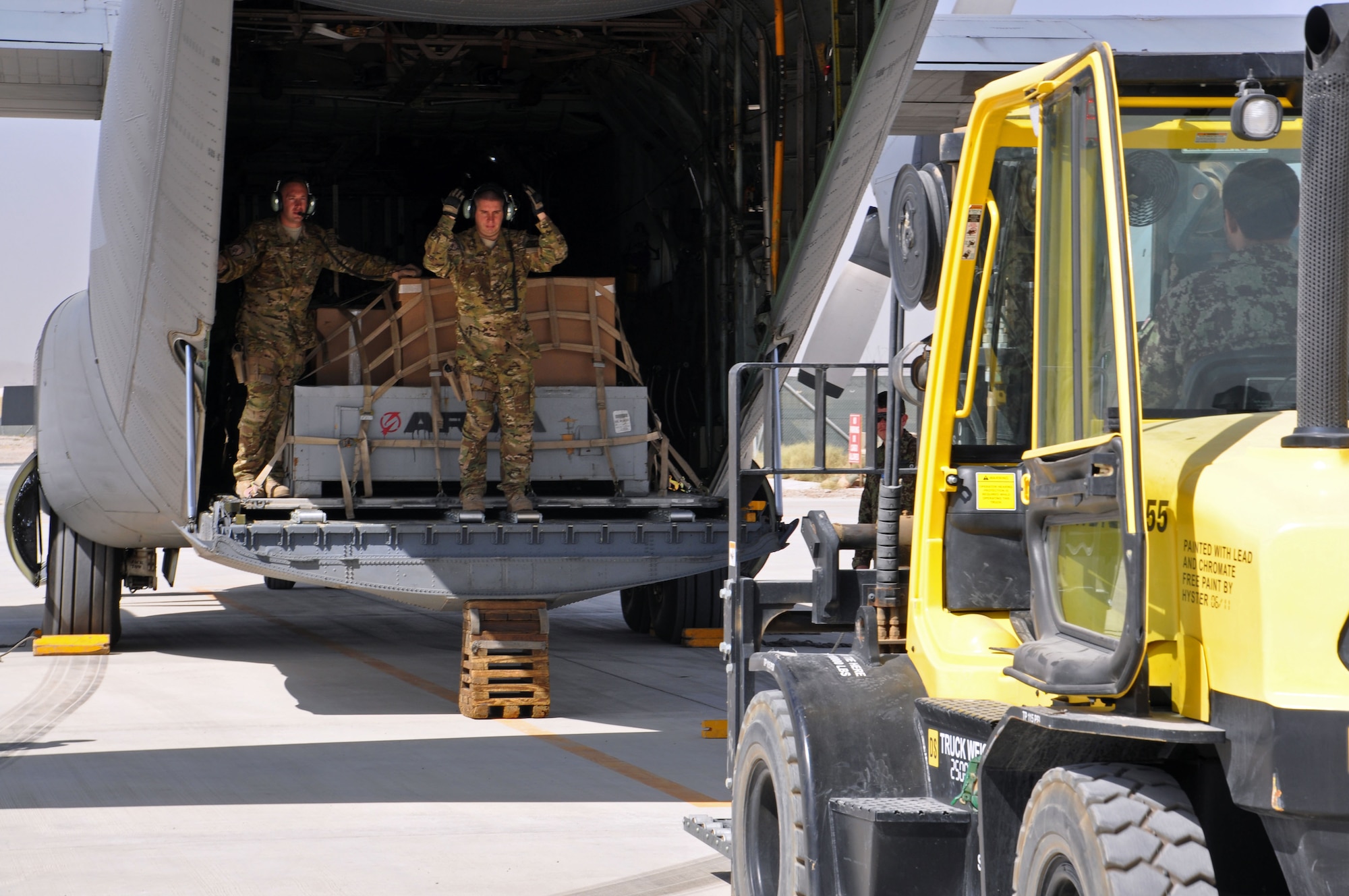 Afghan Air Force members alongside their NATO Air Training Command-Afghanistan advisors unload cargo from the first operational AAF C-130 mission Oct. 10, 2013 at Kandahar Airfield, Afghanistan. The mission was flown by both AAF and coalition pilots with NATC-A between Kabul International Airport, Afghanistan and KAF. (U.S. Air Force photo/Capt. Anastasia Wasem)