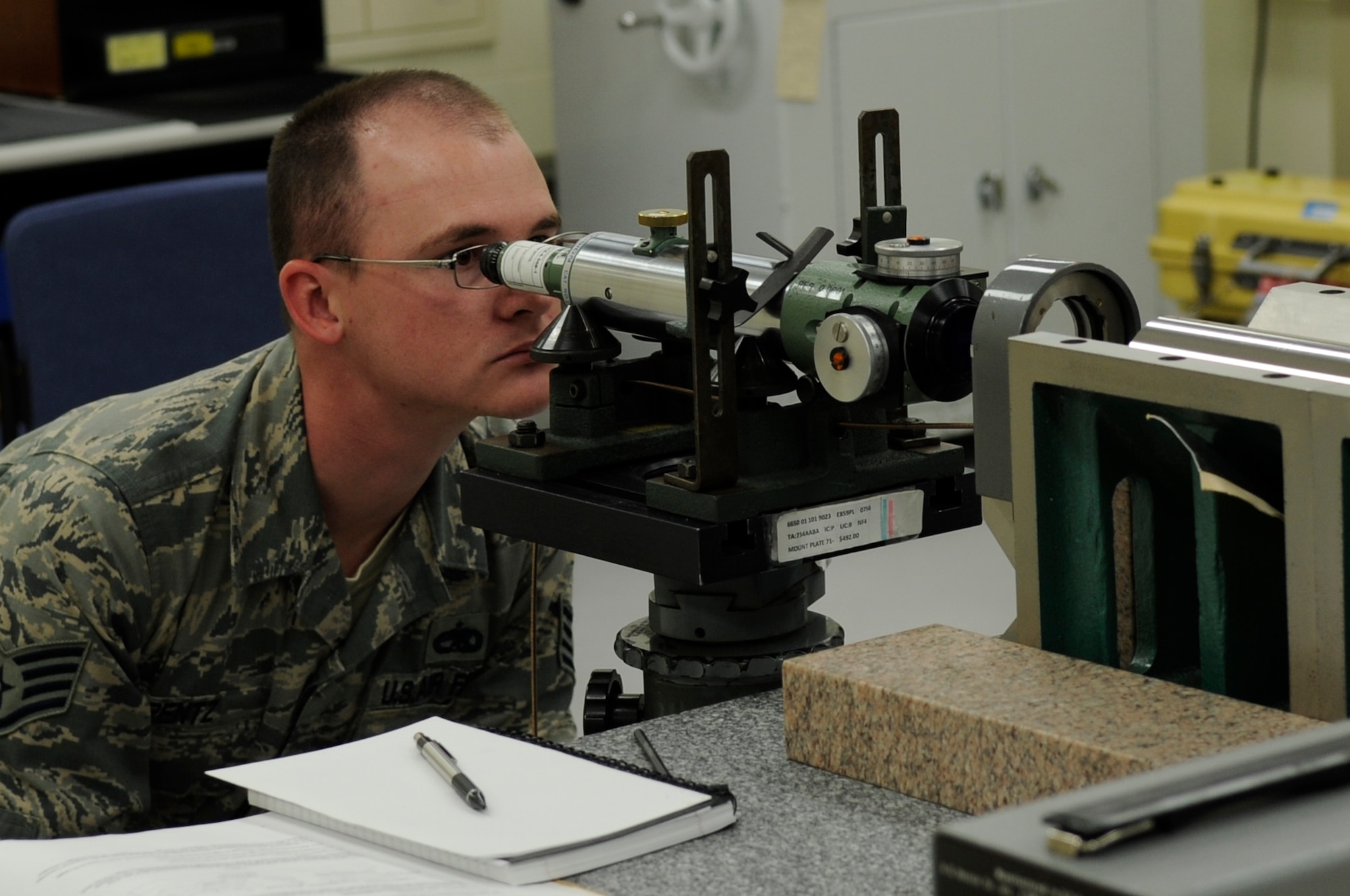 Staff Sgt. Sean Pentz, Component Maintenance Squadron precision measurement equipment laboratory technician, uses a line up sight telescope, an optical micrometer and an optical wedge to calibrate a multiple-target collimator on Kadena Air Base, Japan, Oct. 3, 2013. The collimator is used to calibrate surveillance equipment and can be used to replicate a target at infinity without distortion. (U.S. Air Force photo by Senior Airman Marcus Morris)