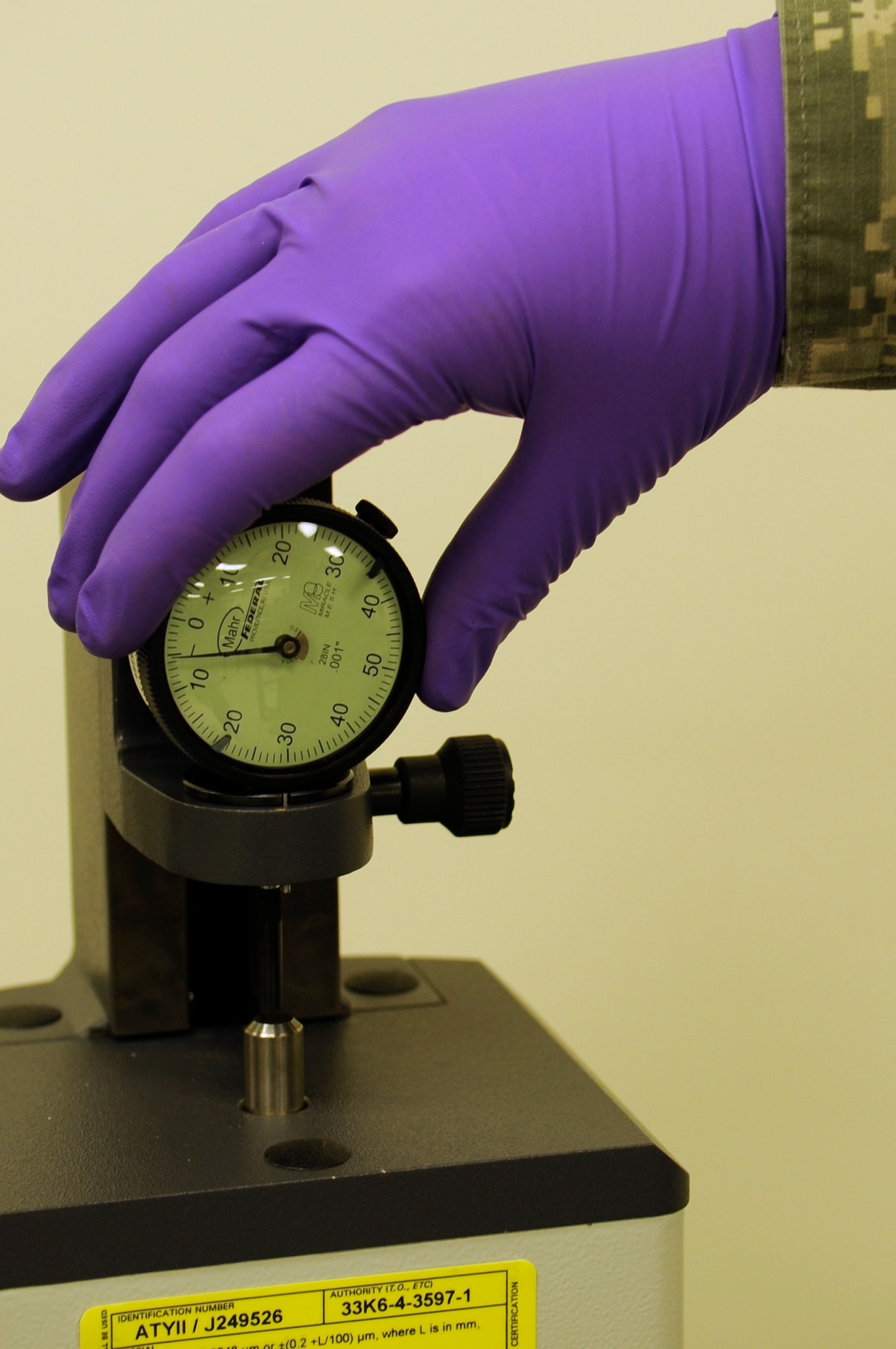 An 18th Component Maintenance Squadron precision measurement equipment laboratory technician calibrates a dial indicator on Kadena Air Base, Japan, Oct. 3, 2013. The dial indicator is used directly on aircraft to test the tolerance of air pressure. (U.S. Air Force photo by Senior Airman Marcus Morris) 