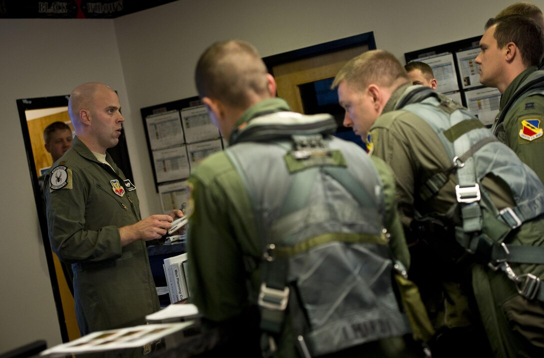 Pilots from the 421st Fighter Squadron listen to a mission briefing before their scheduled sortie Sept. 11, 2013, at Hill Air Force Base, Utah. The squadron is flying at combat-mission ready status after more than three months of flying drastically reduced hours during sequestration. The 4th FS, the 421st’s sister-squadron, stood down completely during the sequester.  