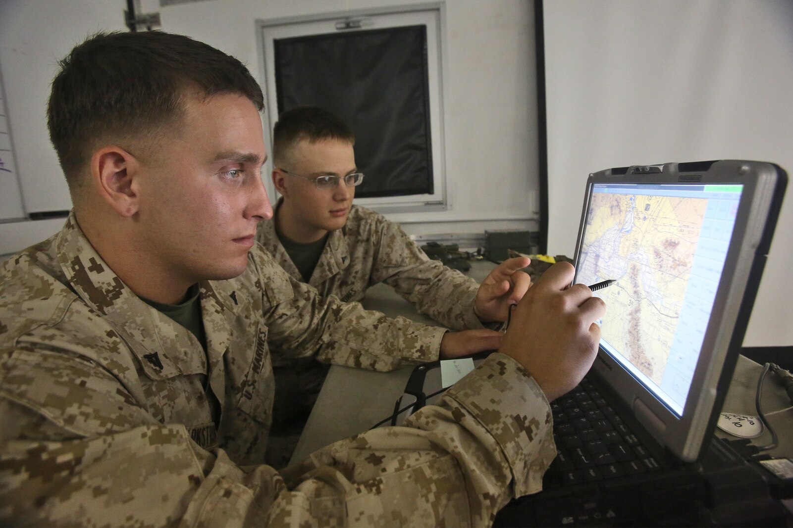Lance Cpl. Jacob A. Barkstrom, left, and Lance Cpl. Corey R. Dettmann, right, data network systems technicians with Combat Logistics Company 16, Combat Logistics Regiment 15, 1st Marine Logistics Group, locate a convoy using a Blue Force Tracker in a combat operations center during Weapons and Tactics Instructor Course 1-14 aboard Marine Corps Air Station Yuma, Ariz., Oct. 2, 2013. The COC provided logistical support and services to units from 1st MLG, including CLR-15, CLR-1, CLR-17, 7th Engineer Support Battalion, 1st Maintenance Battalion and 1st Medical Battalion during WTI 1-14. 