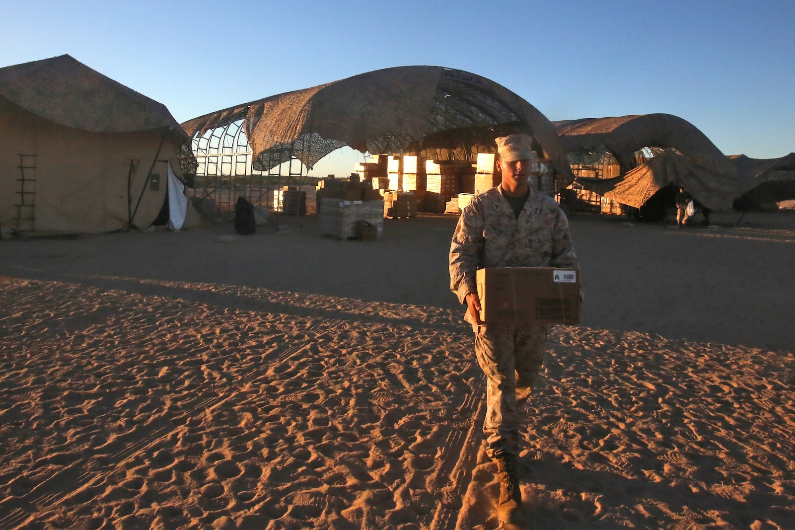 Private First Class Felipe S. Mangabeira, an engineer equipment operator with Combat Logistics Company 16, Combat Logistics Regiment 15, 1st Marine Logistics Group, carries a box of rations to a convoy at the Cannon Air Defense Complex supply yard during Weapons and Tactics Instructor Course 1-14 in Yuma, Ariz., Oct. 3, 2013. Daily convoys were organized by CLC-16 to provide food, fuel and equipment across Arizona in support of WTI 1-14 and traveled as far as 350 miles for a single resupply operation.  