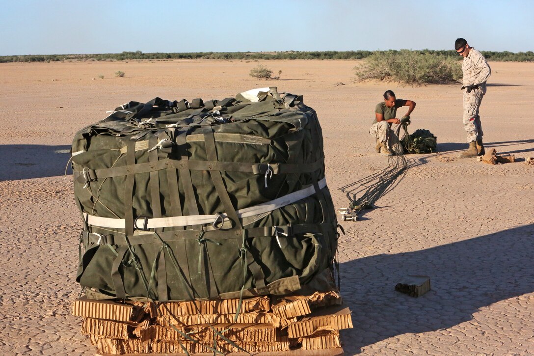 Lance Cpl. Krista Jennings and Lance Cpl. Anthony Martini, parachute riggers with Air Delivery Platoon, Landing Support Company, Combat Logistics Regiment 17, 1st Marine Logistics Group, prepare a container delivery system for an airlift during Weapons and Tactics Instructor Course 1-14 near Yuma, Ariz., Oct. 1, 2013. Parachute riggers are essential for transporting heavy loads of food, fuel and ammunition with aircraft such as the C-130 or MV-22 Osprey, enabling ground units to receive supplies faster, safer and at farther distances than they would from a convoy. 